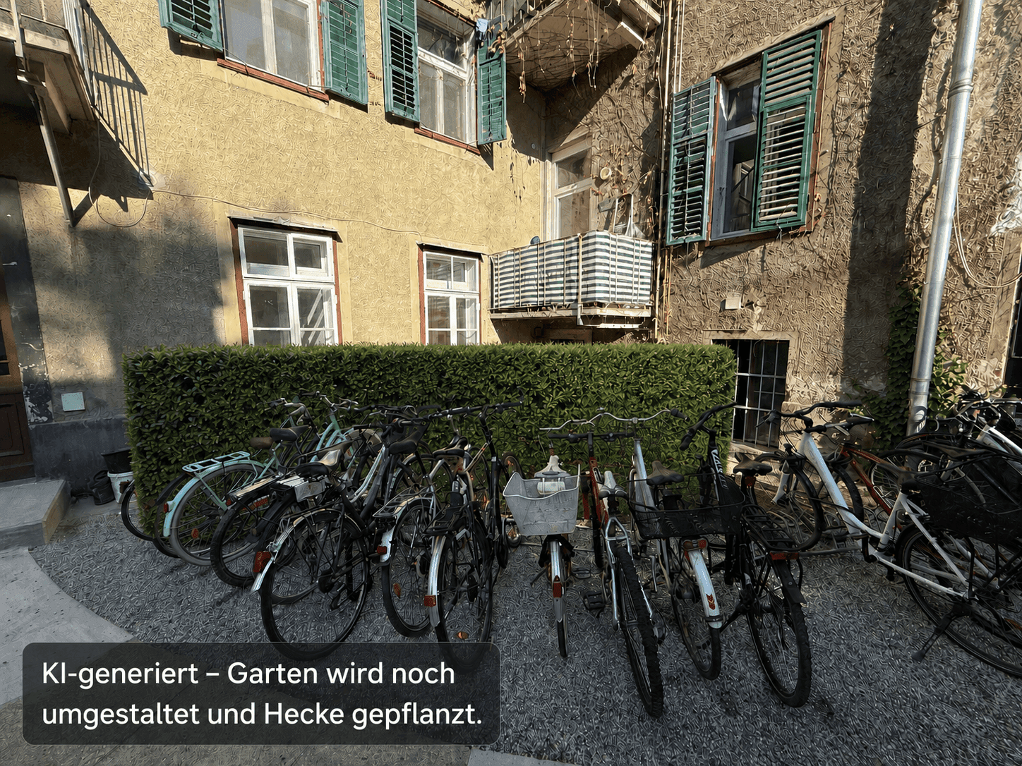 Außenansicht eines Gebäudes mit Fahrrädern und einer Hecke im Vordergrund.