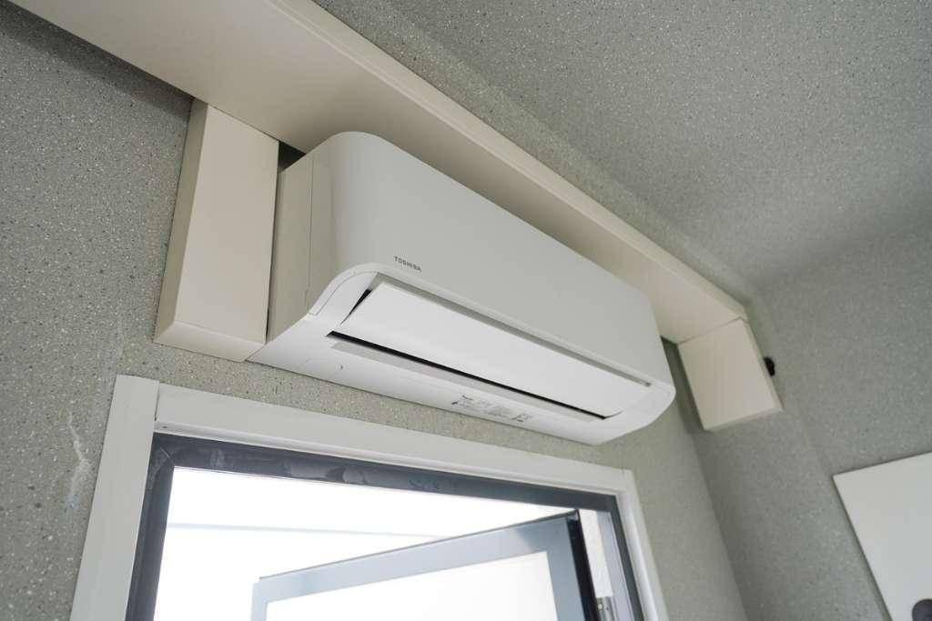 Moderne Klimaanlage über einem Türrahmen in einem Innenraum installiert.
