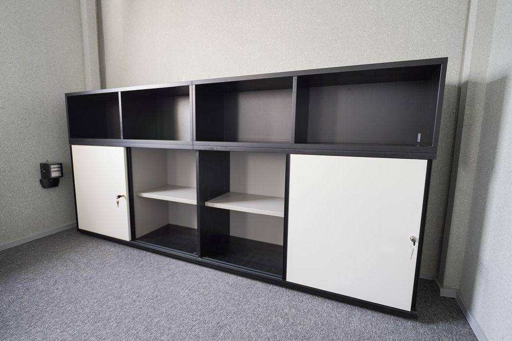 Geräumiger Büroschrank mit offenen Fächern und abschließbaren Türen in einem modernen Büroraum für effiziente Organisation.