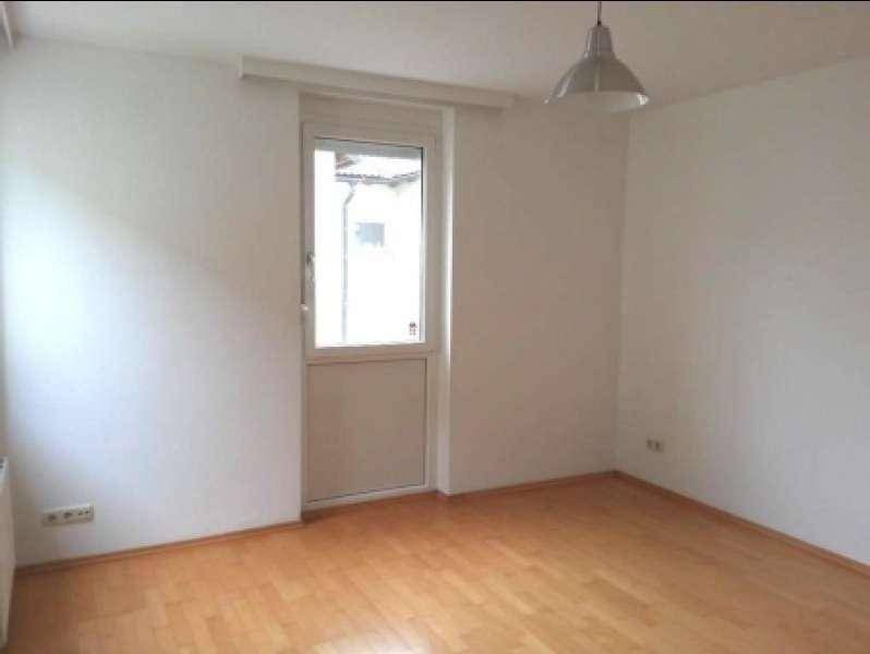 Leerer Raum mit Parkettboden und einem Fenster, ideal für Schlafzimmer oder Büro.
