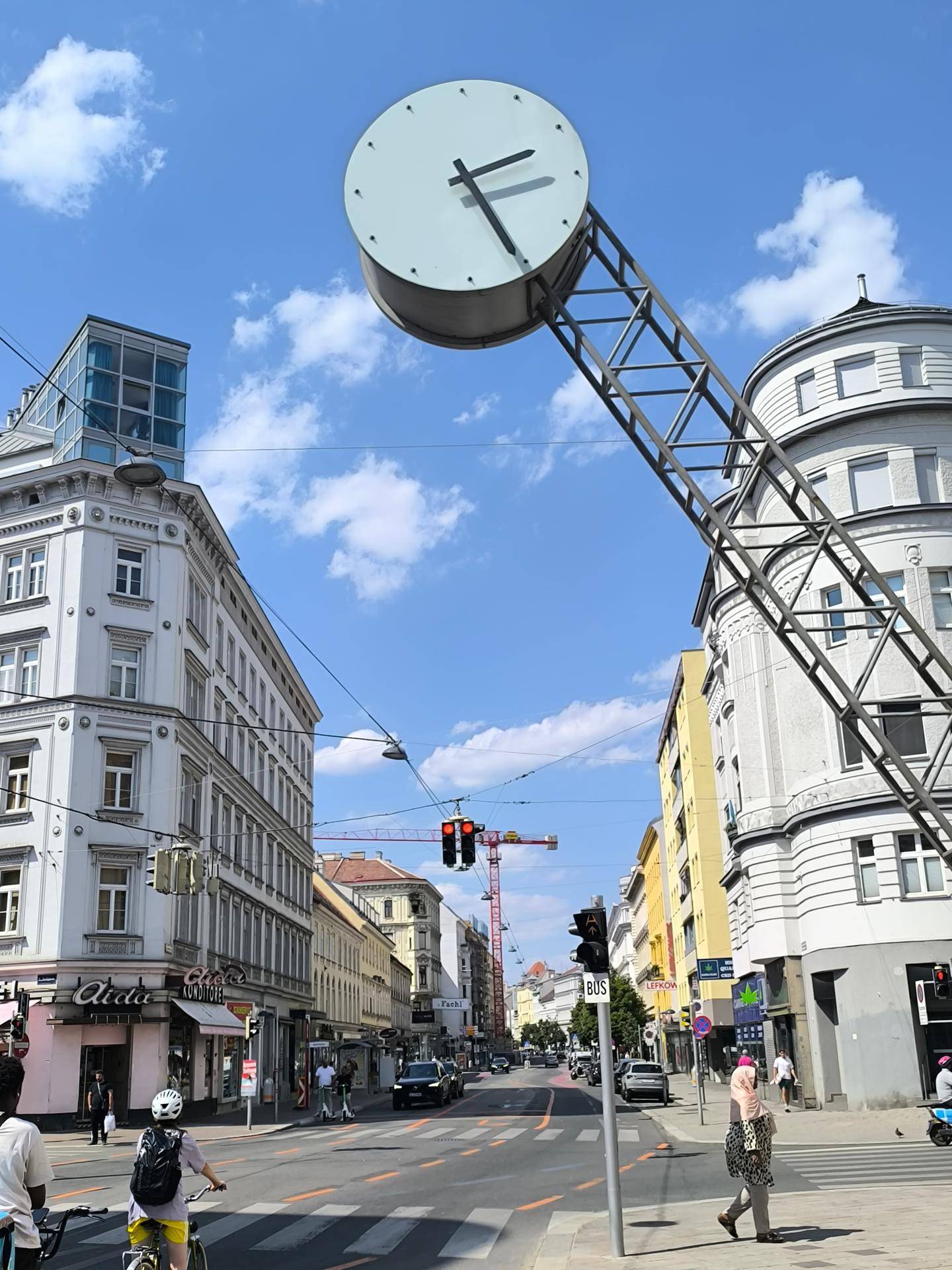 Stadtansicht mit einer großen Uhr im Vordergrund, historischen Gebäuden und einer belebten Straße.