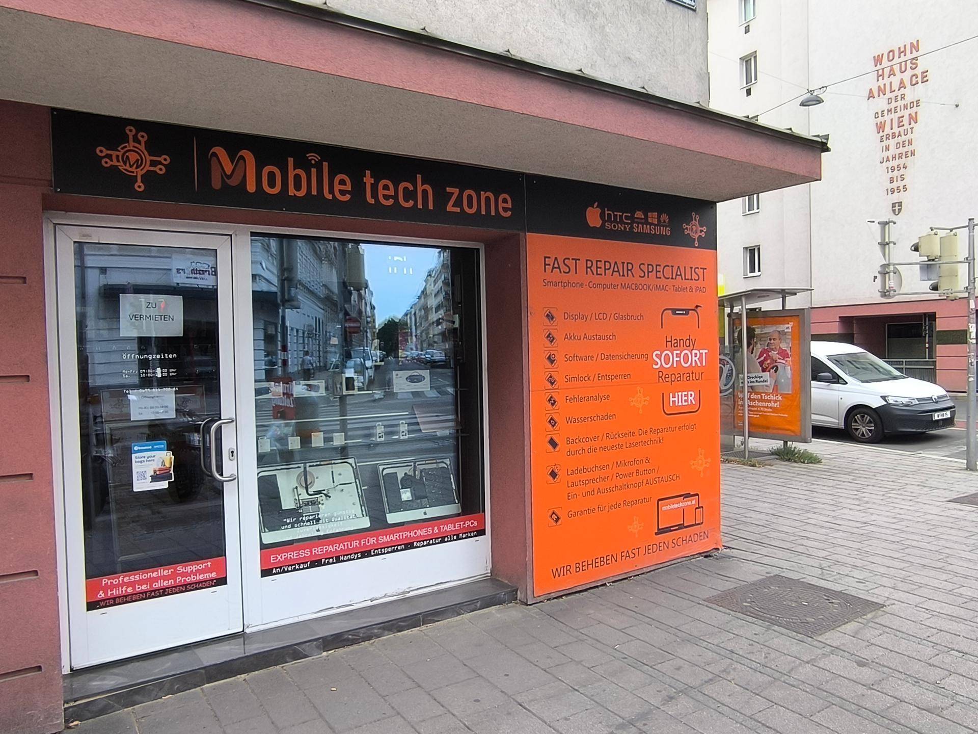 Vorderansicht eines Geschäfts für Handy-Reparaturen und Technik in einer städtischen Umgebung.