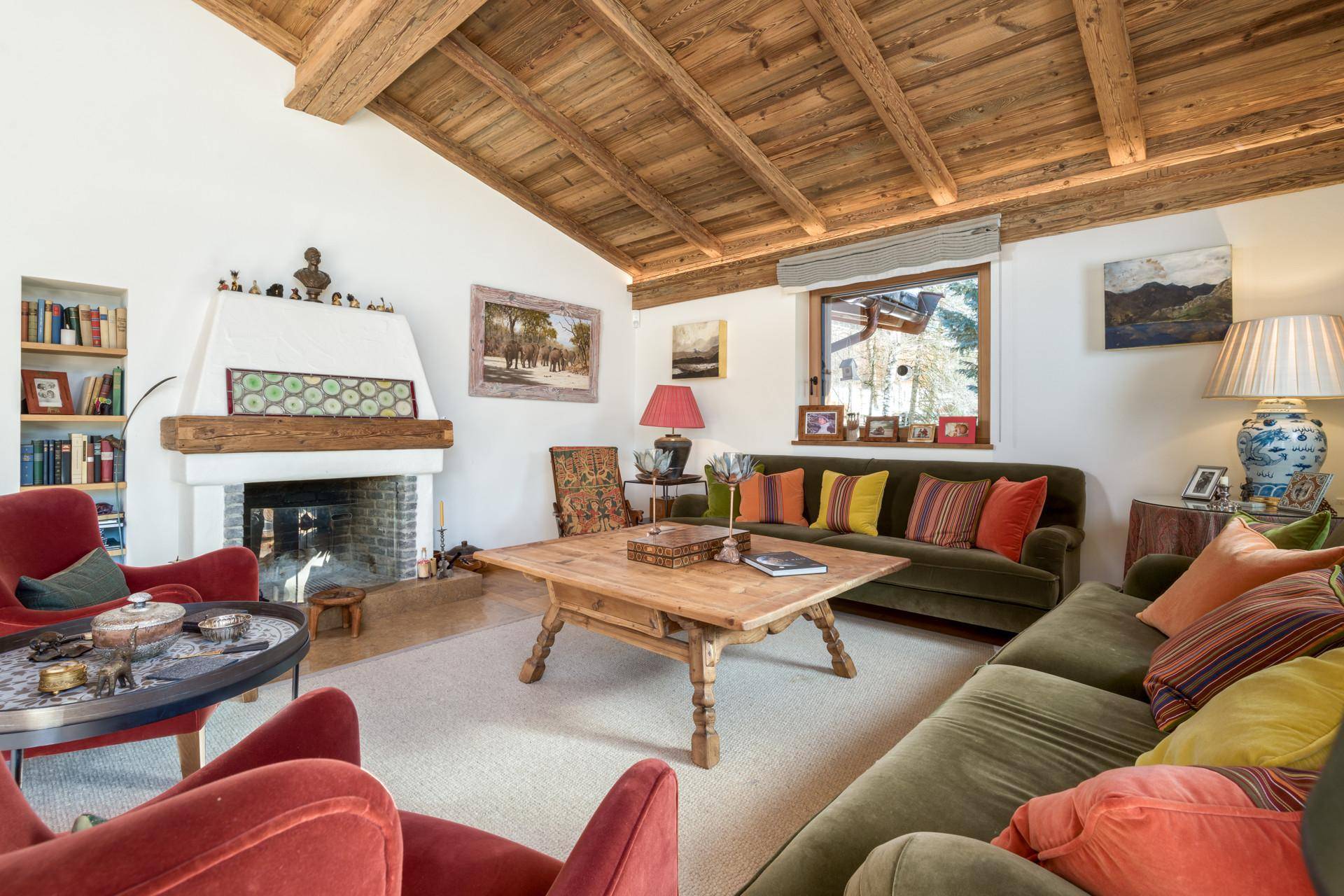 Gemütliches Wohnzimmer mit Kamin, Holzbalkendecke und traditioneller Einrichtung.