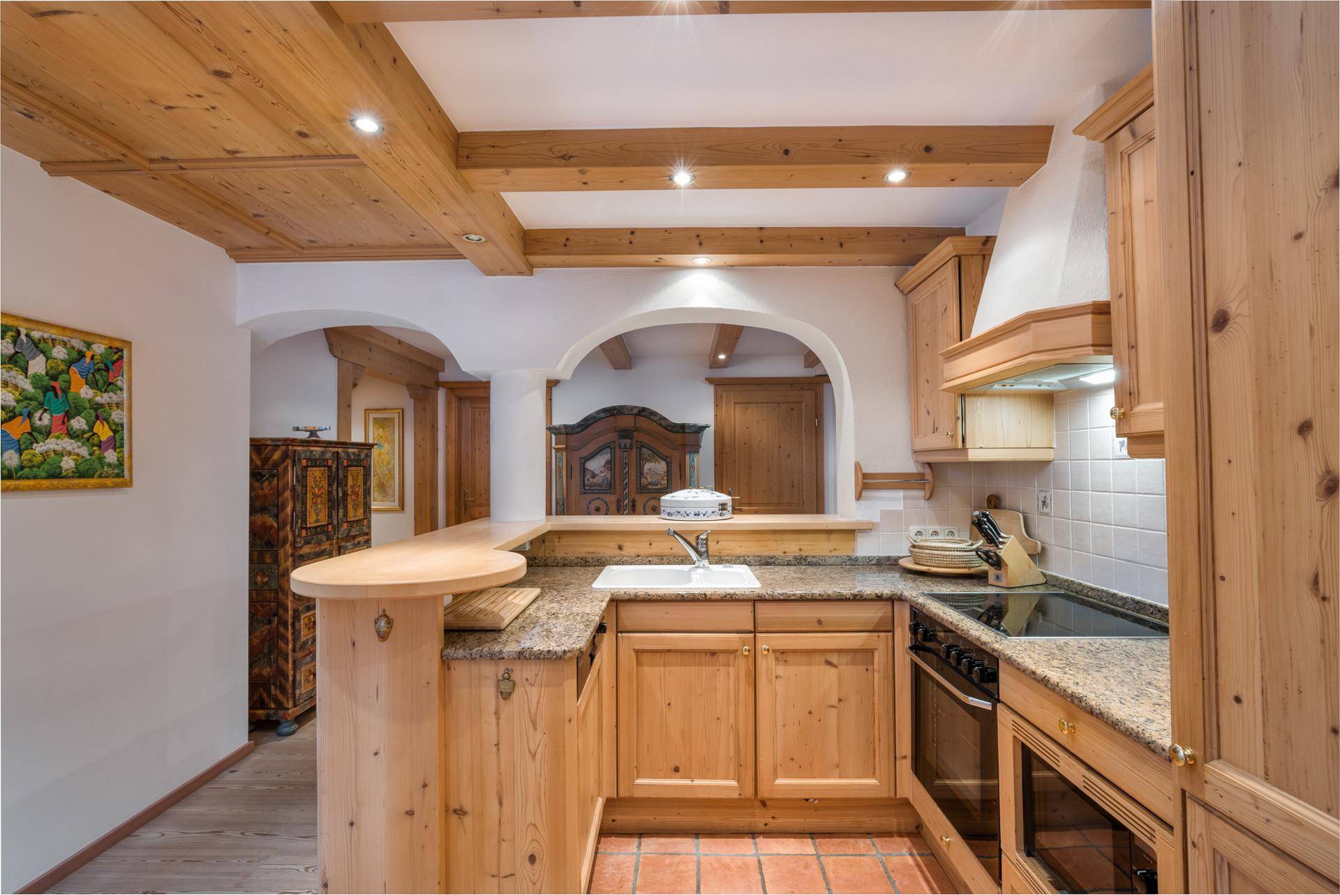 Traditionelle Holzküche mit Granitarbeitsplatte, Einbaugeräten und rustikalem Charme.