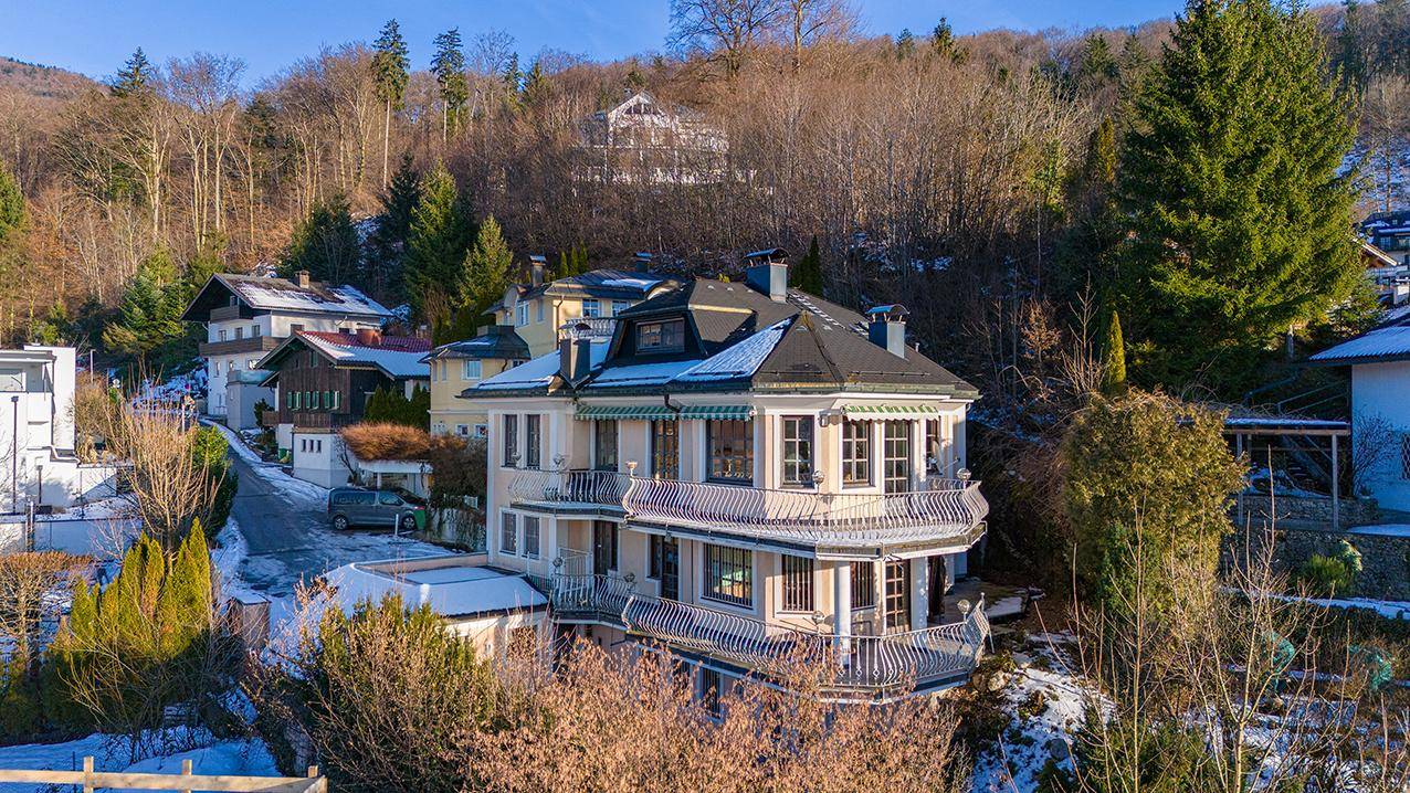Luftaufnahme der Villa mit mehreren Balkonen, umgeben von Bäumen und verschneiter Landschaft.