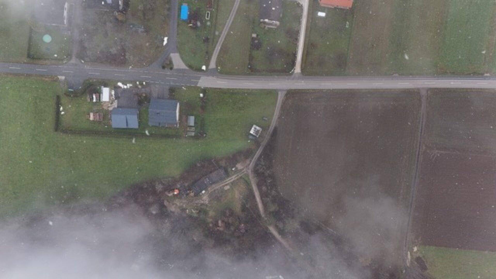 Luftaufnahme des Anwesens mit Wohnhaus, Wiese und Feldern, teilweise von Wolken verdeckt.