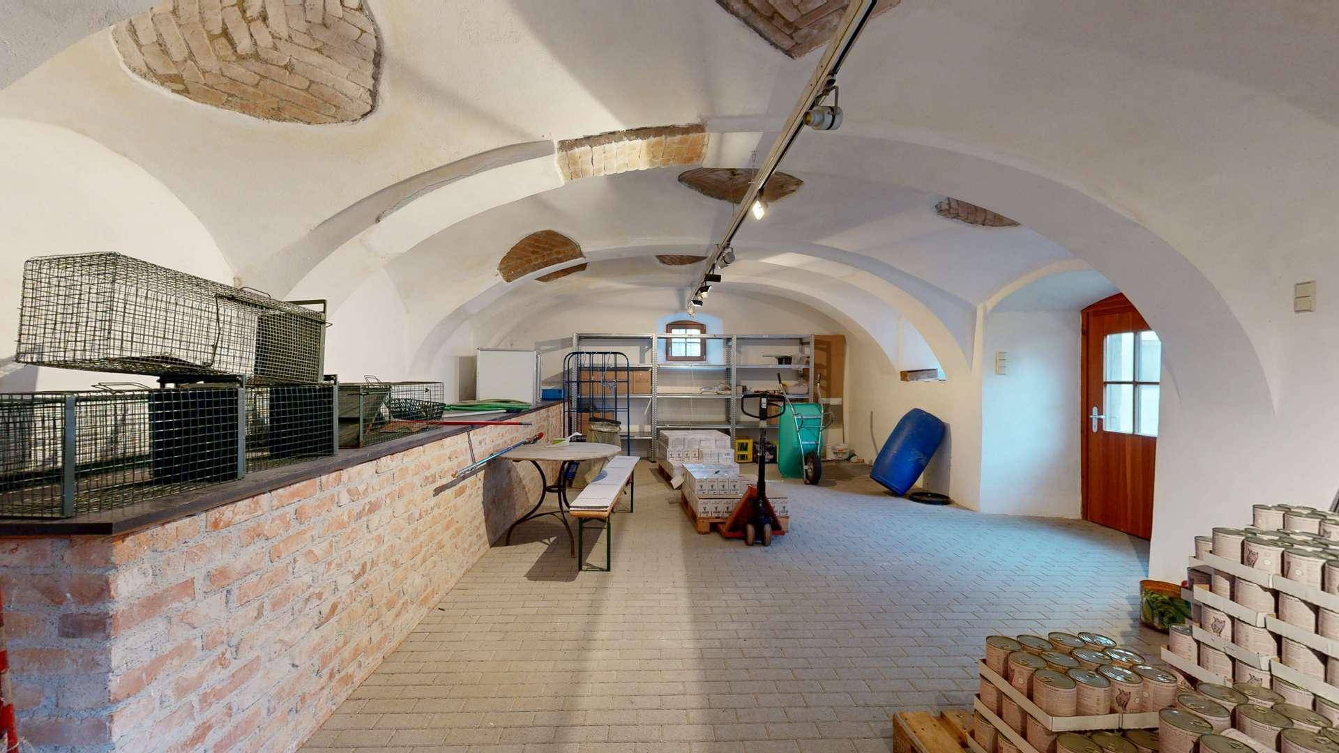 Historischer Gewölbekeller mit Ziegelwänden und Lagerflächen.