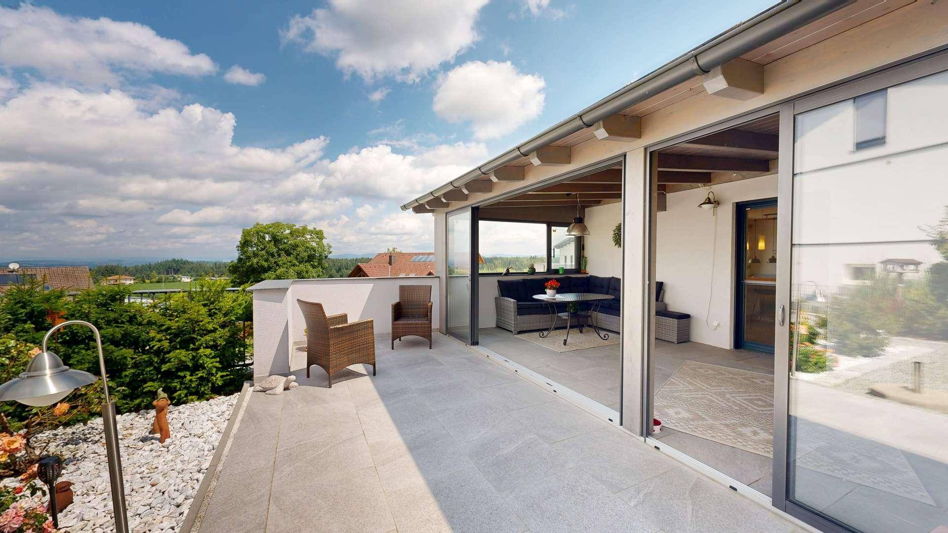 Geräumige Terrasse mit Sitzgelegenheiten und weitem Blick über die Landschaft, ideal zum Entspannen.