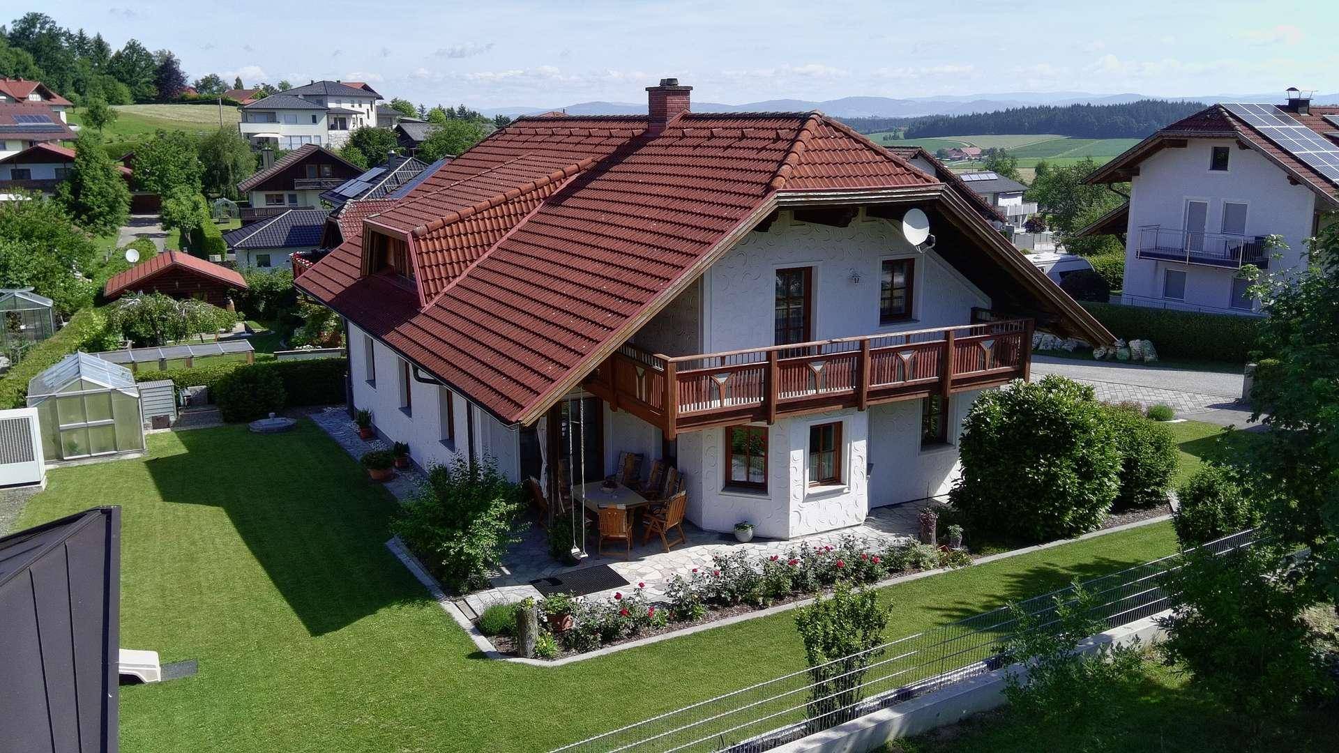 Luftaufnahme des Hauses mit rotem Ziegeldach und umliegender ländlicher Bebauung.