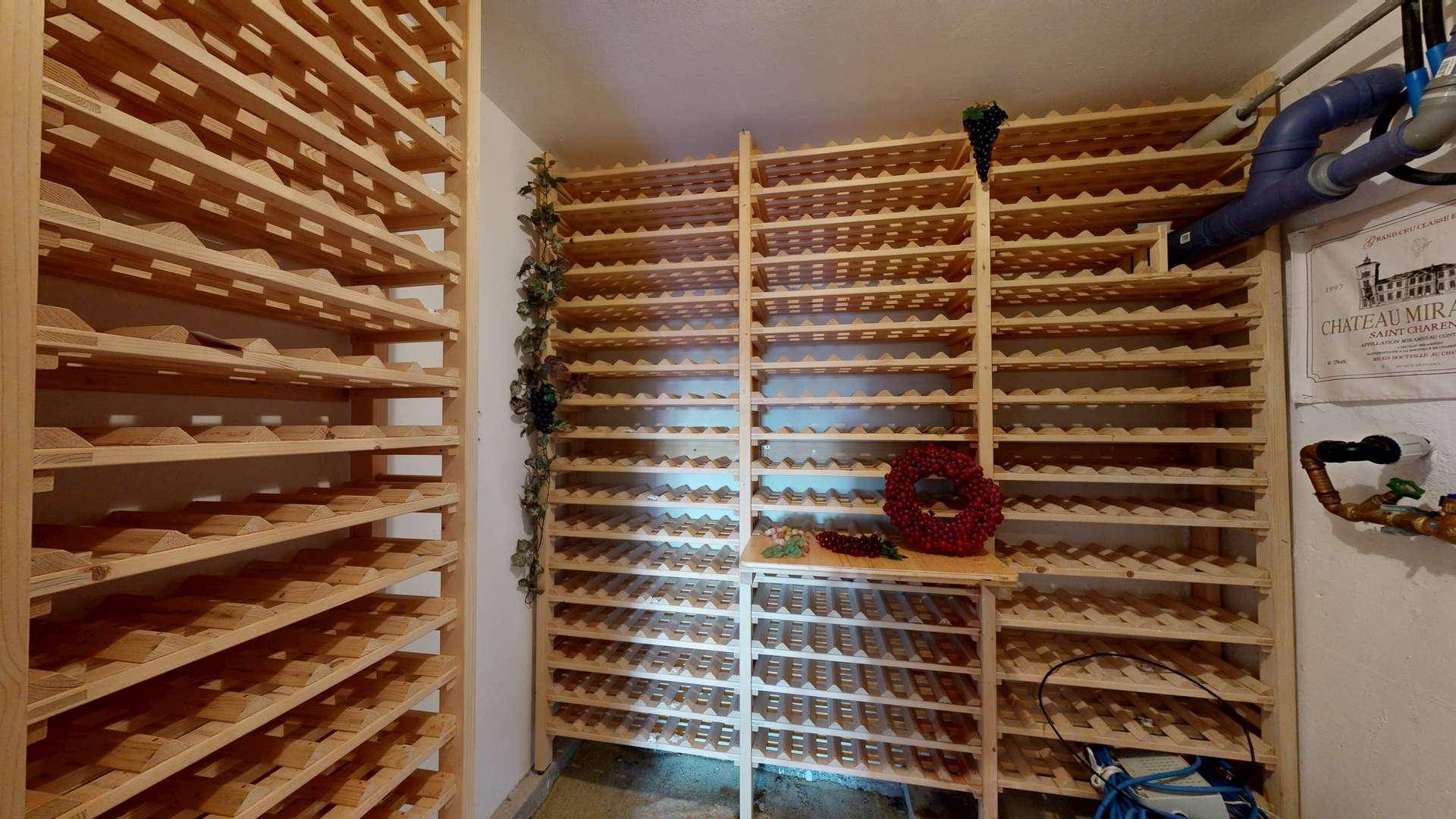 Gut ausgestatteter Weinkeller mit zahlreichen Holzregalen zur Lagerung einer großen Weinsammlung.