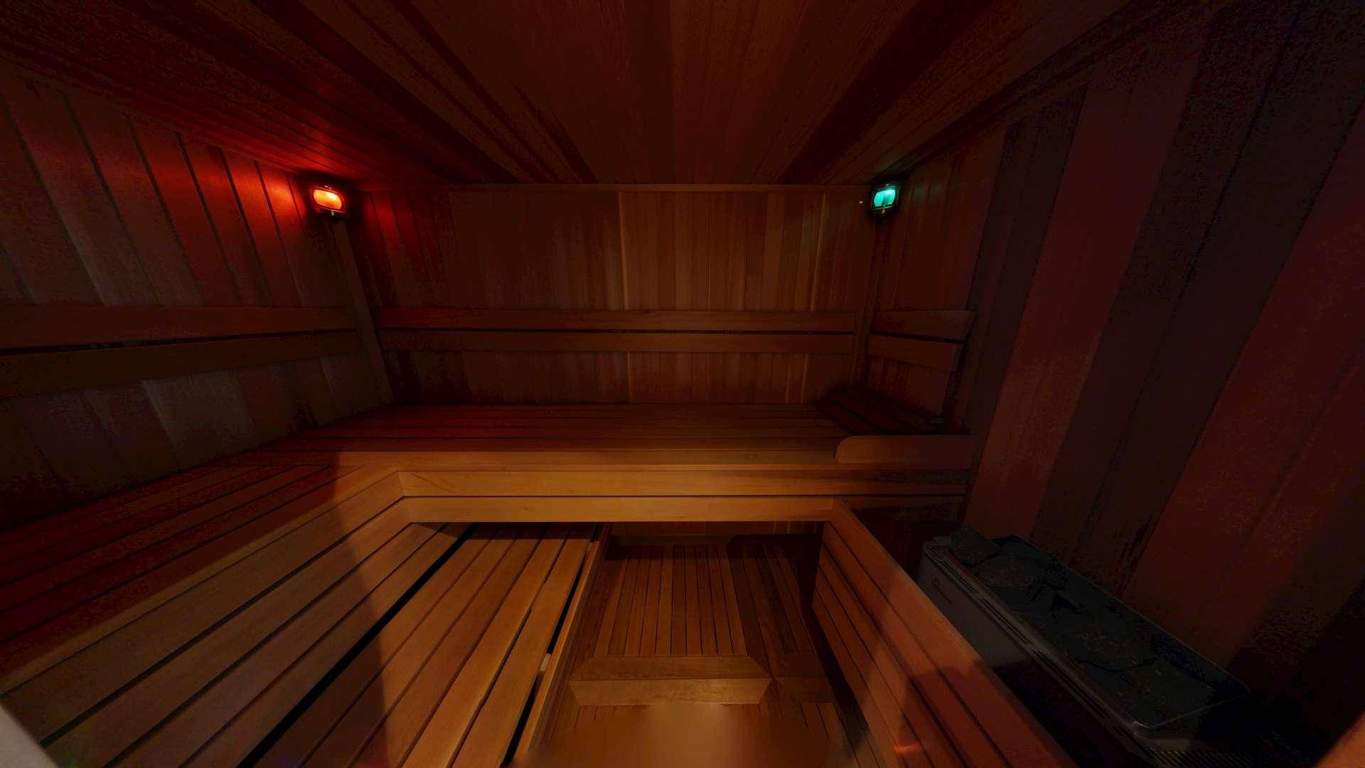 Gemütliche Holzsauna mit Bänken und stimmungsvoller Beleuchtung für entspannende Momente.