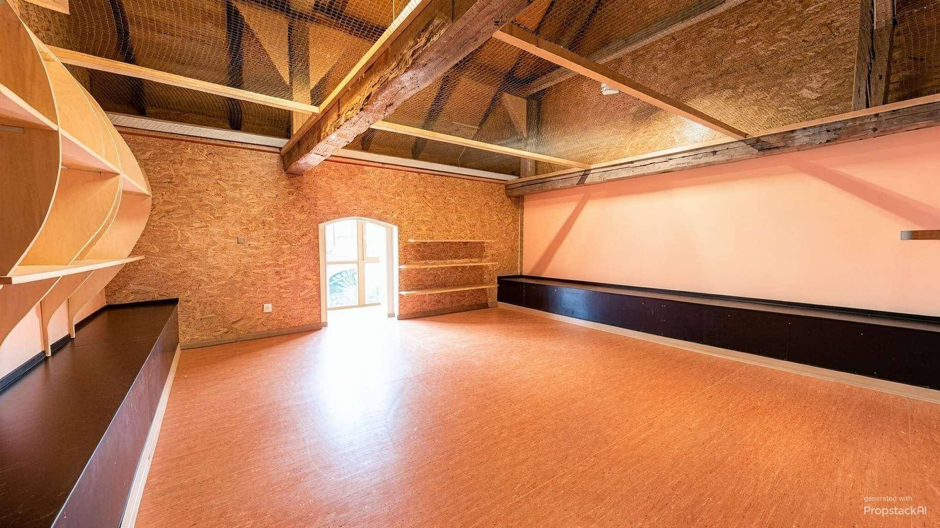 Geräumiger Dachboden mit sichtbaren Holzbalken und OSB-Platten an den Wänden.