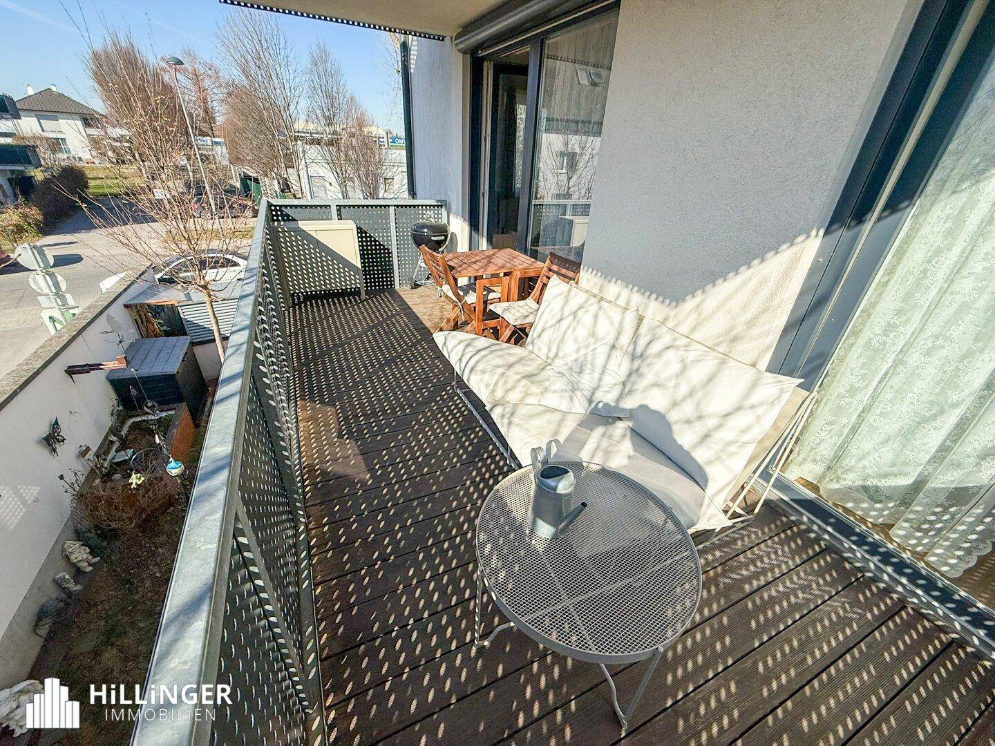 Geräumiger Balkon mit Holzboden und Sitzgelegenheiten, bietet einen Blick auf die Umgebung.
