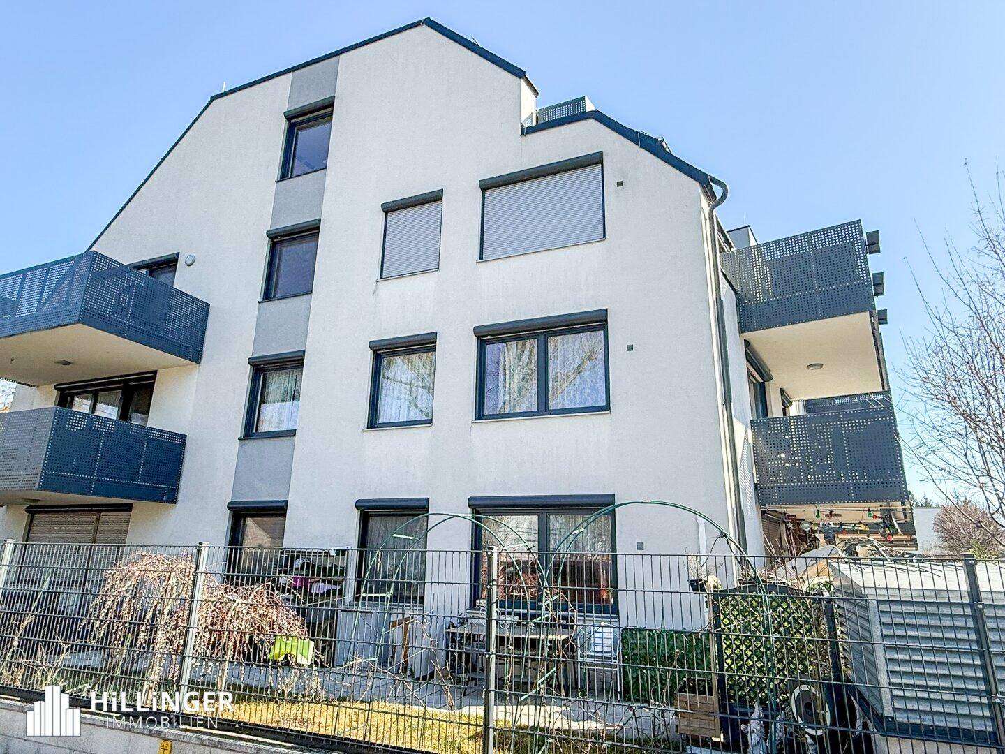 Ansicht des modernen Wohngebäudes mit Balkonen und Terrassen im Erdgeschoss.