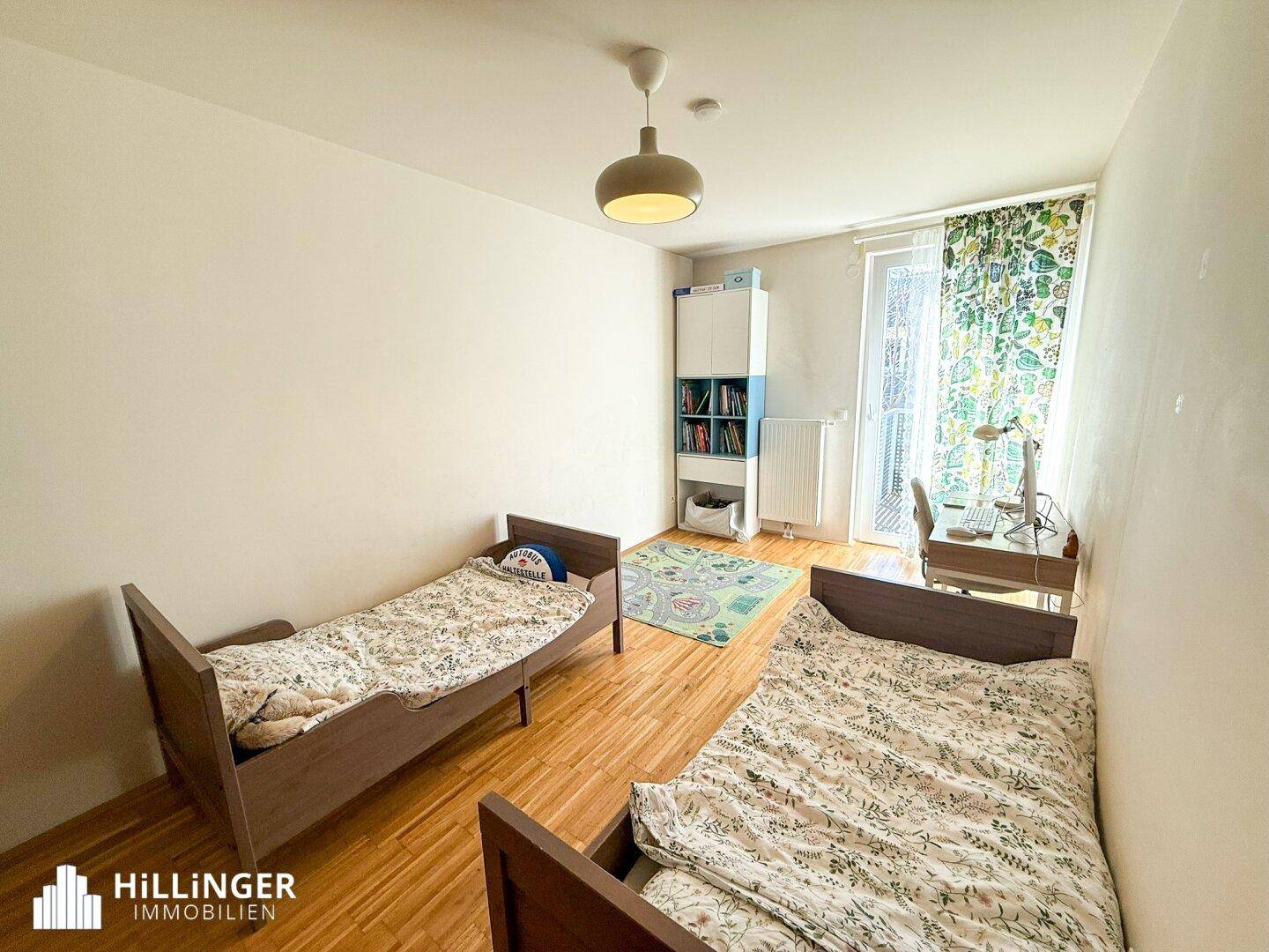 Kinderzimmer mit zwei Einzelbetten, Schreibtisch und Fenster, ideal für Geschwister oder Gäste.