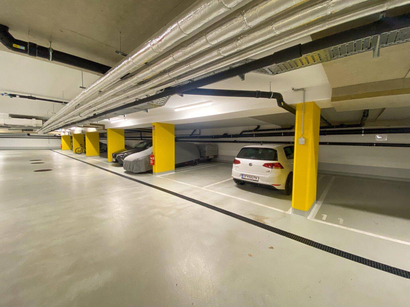 Saubere und gut beleuchtete Tiefgarage mit ausreichend Parkmöglichkeiten.