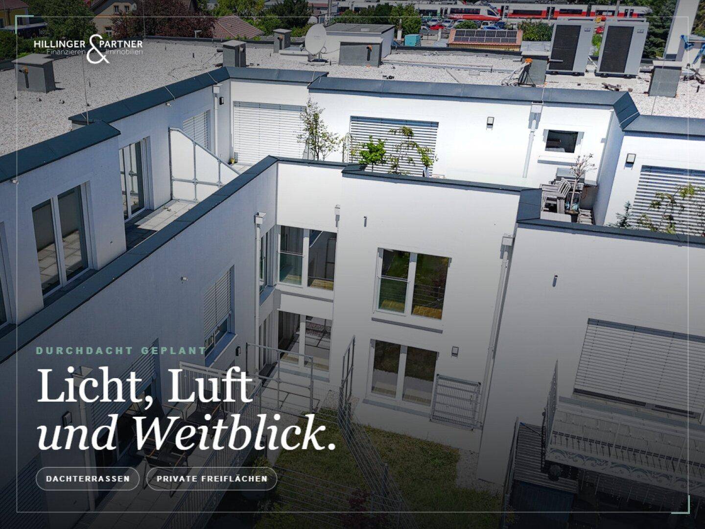 Blick von oben auf die Dachterrassen und den Innenhof eines modernen Wohnkomplexes.