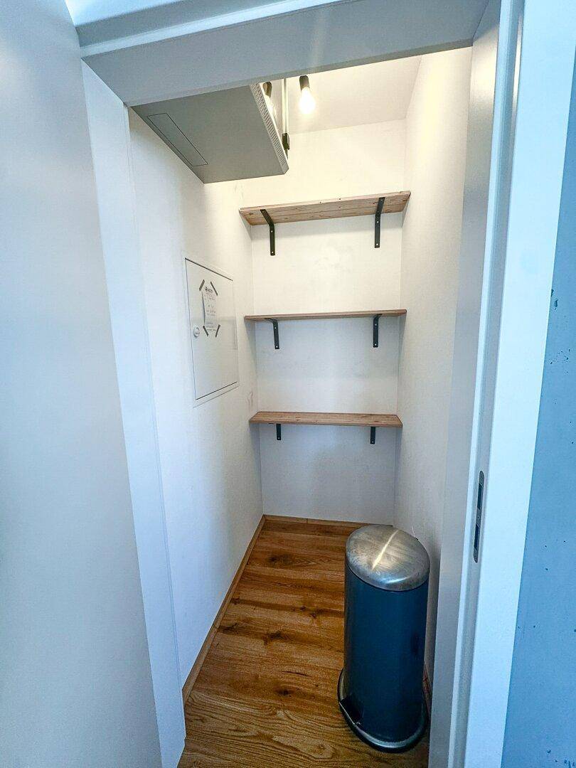 Praktischer Abstellraum mit Holzregalen und ausreichend Platz für Haushaltsgegenstände.
