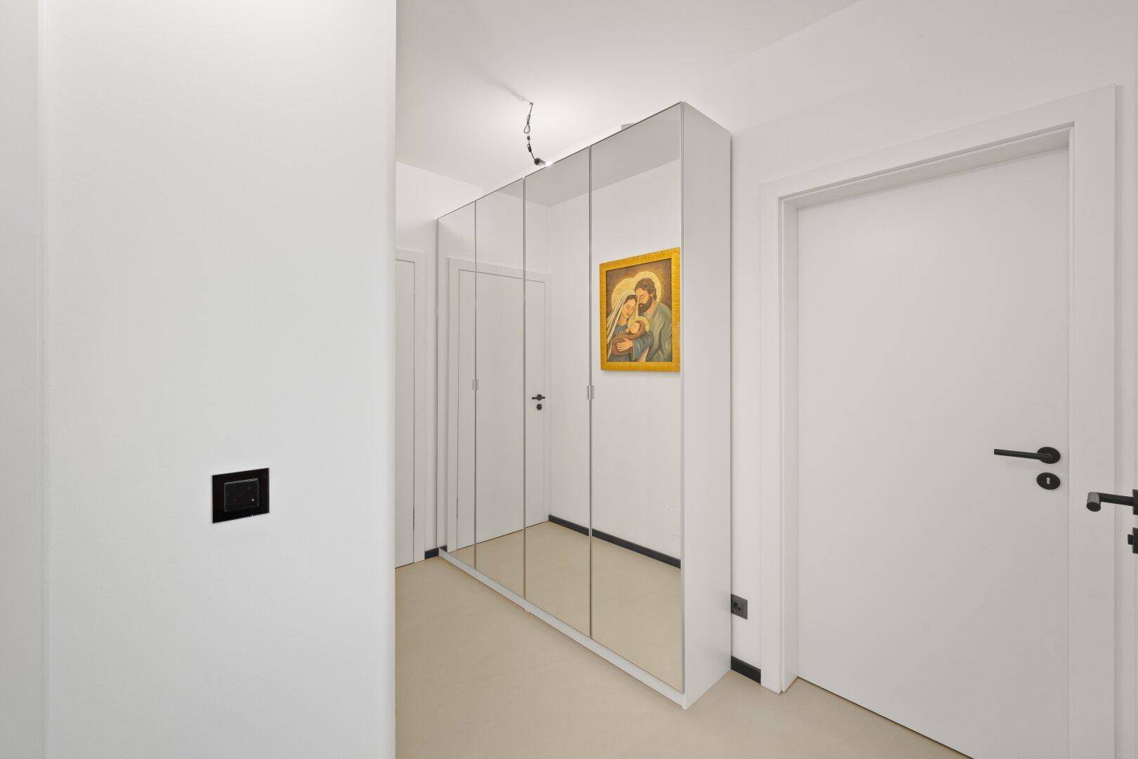 Heller Flur mit integriertem Spiegelschrank, der den Raum optisch vergrößert.