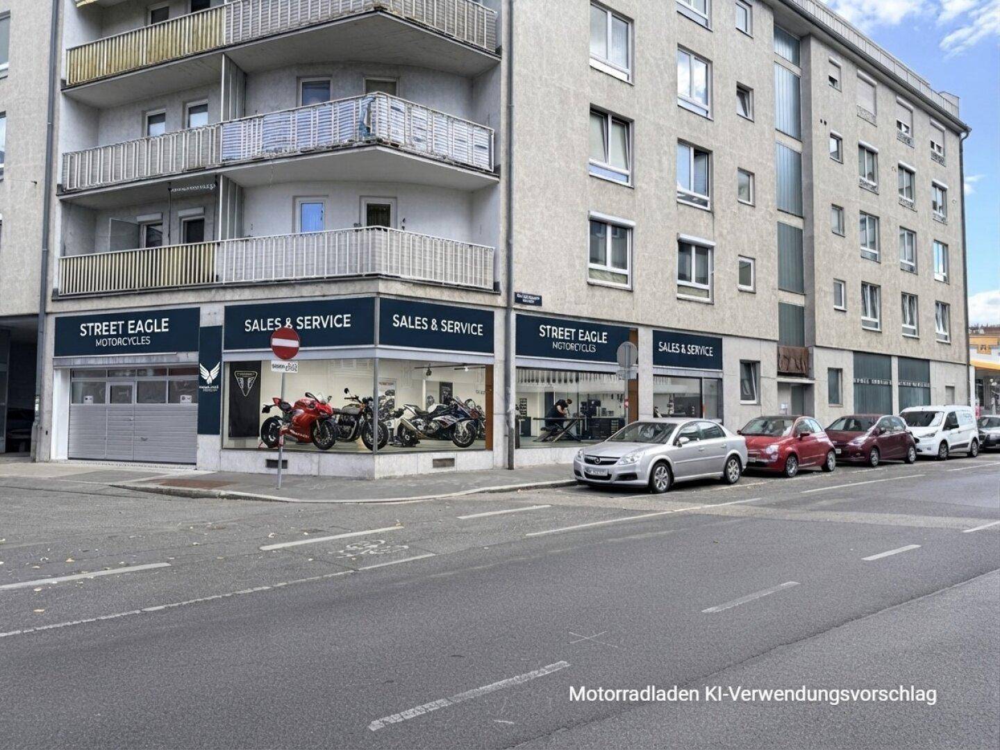 Gebäudeansicht mit Schaufenstern, die einen Motorradladen visualisieren, und parkenden Fahrzeugen auf der Straße.