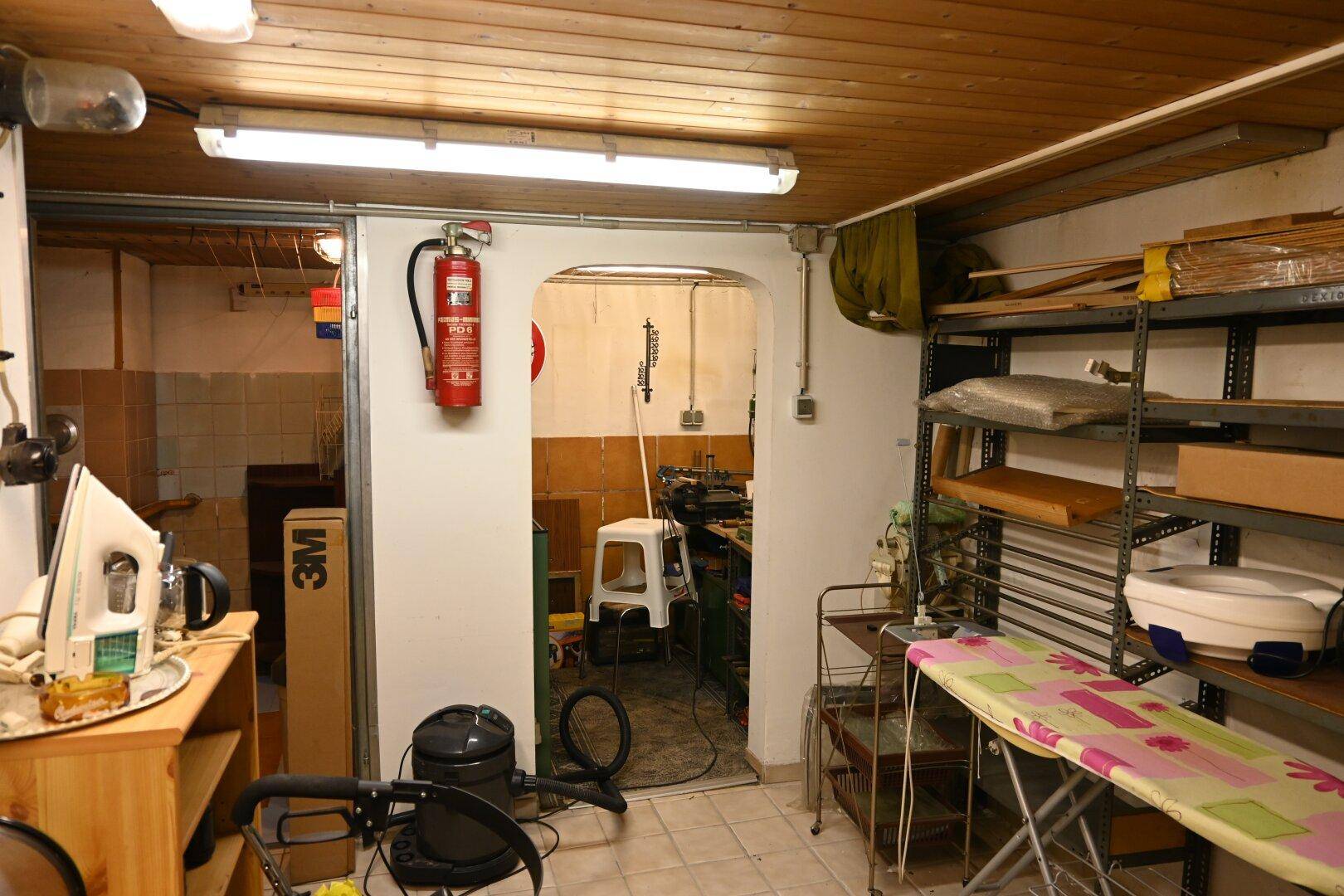 Kellerraum mit Regalen und Werkstattbereich, ideal für Lagerung und Hobby.