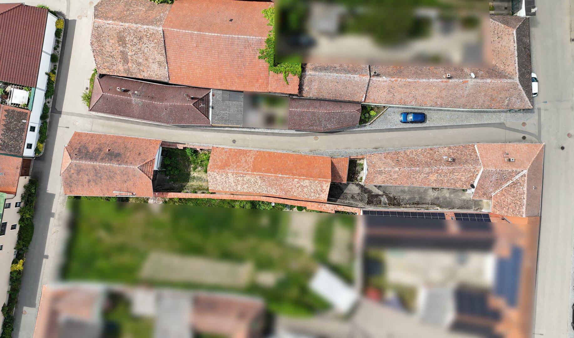 Luftaufnahme eines ländlichen Anwesens mit mehreren Gebäuden und Gärten.