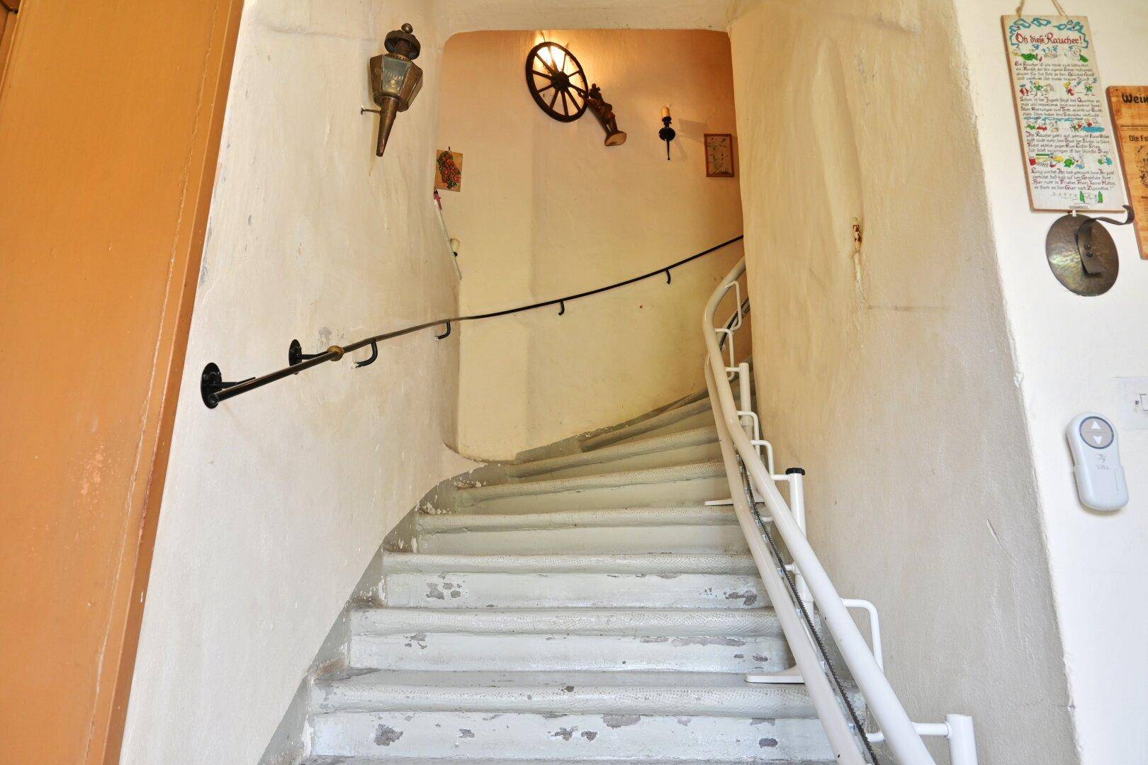 Historisches Treppenhaus mit Handlauf und dekorativen Wandelementen.