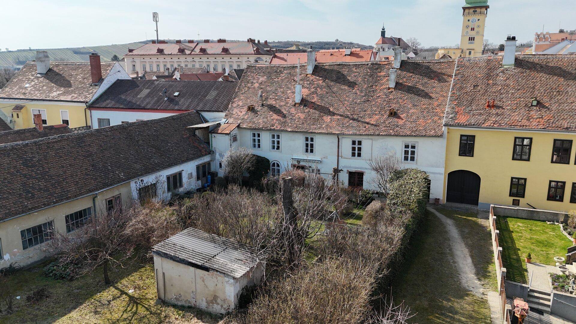 Weitläufige Luftaufnahme eines historischen Stadtteils mit vielen Dächern und einem Turm.