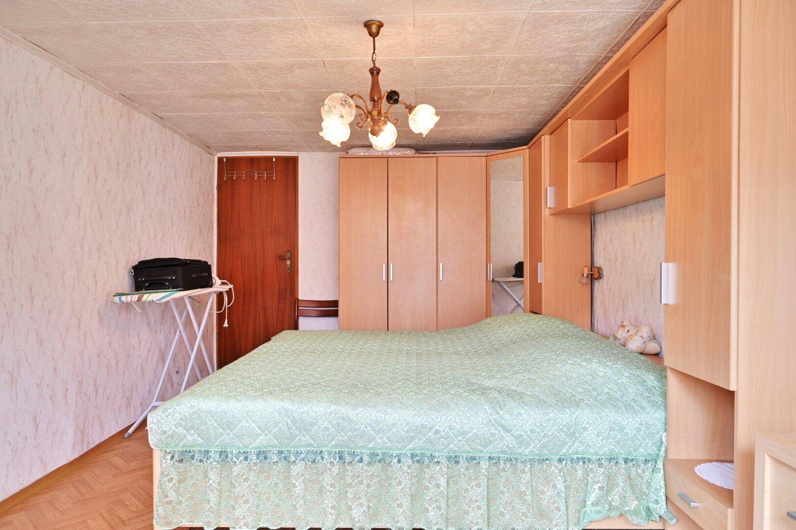 Schlafzimmer mit Doppelbett, Einbauschränken und Holzdecke im traditionellen Stil.