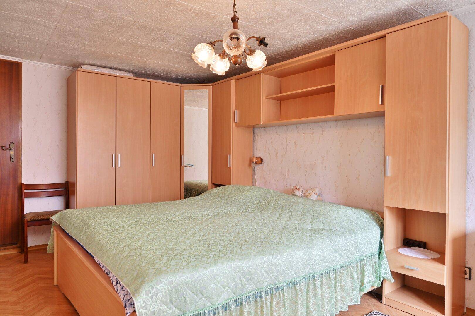 Helles Schlafzimmer mit großem Bett, Holzdecke und praktischen Einbauschränken.