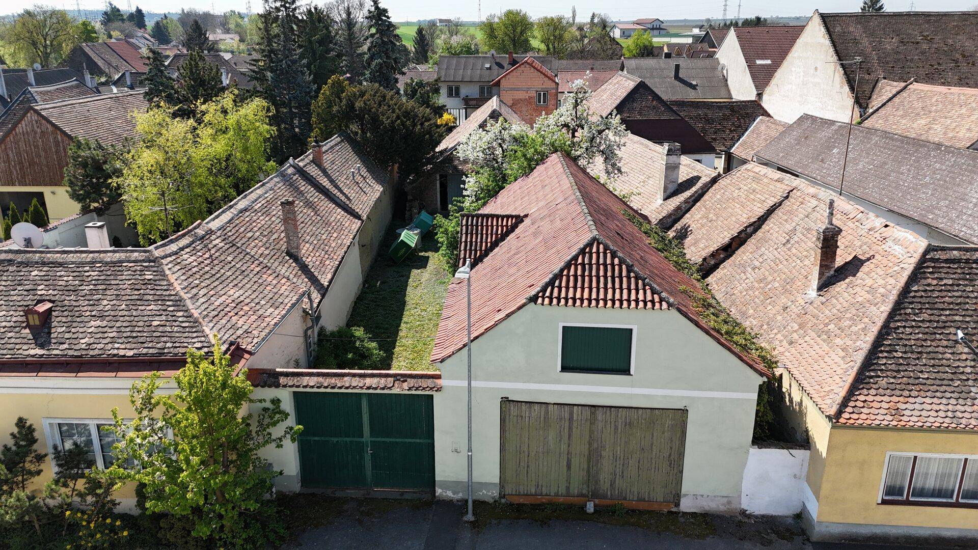 Luftaufnahme des Anwesens mit Hauptgebäude, Nebengebäude und angrenzenden Gärten.