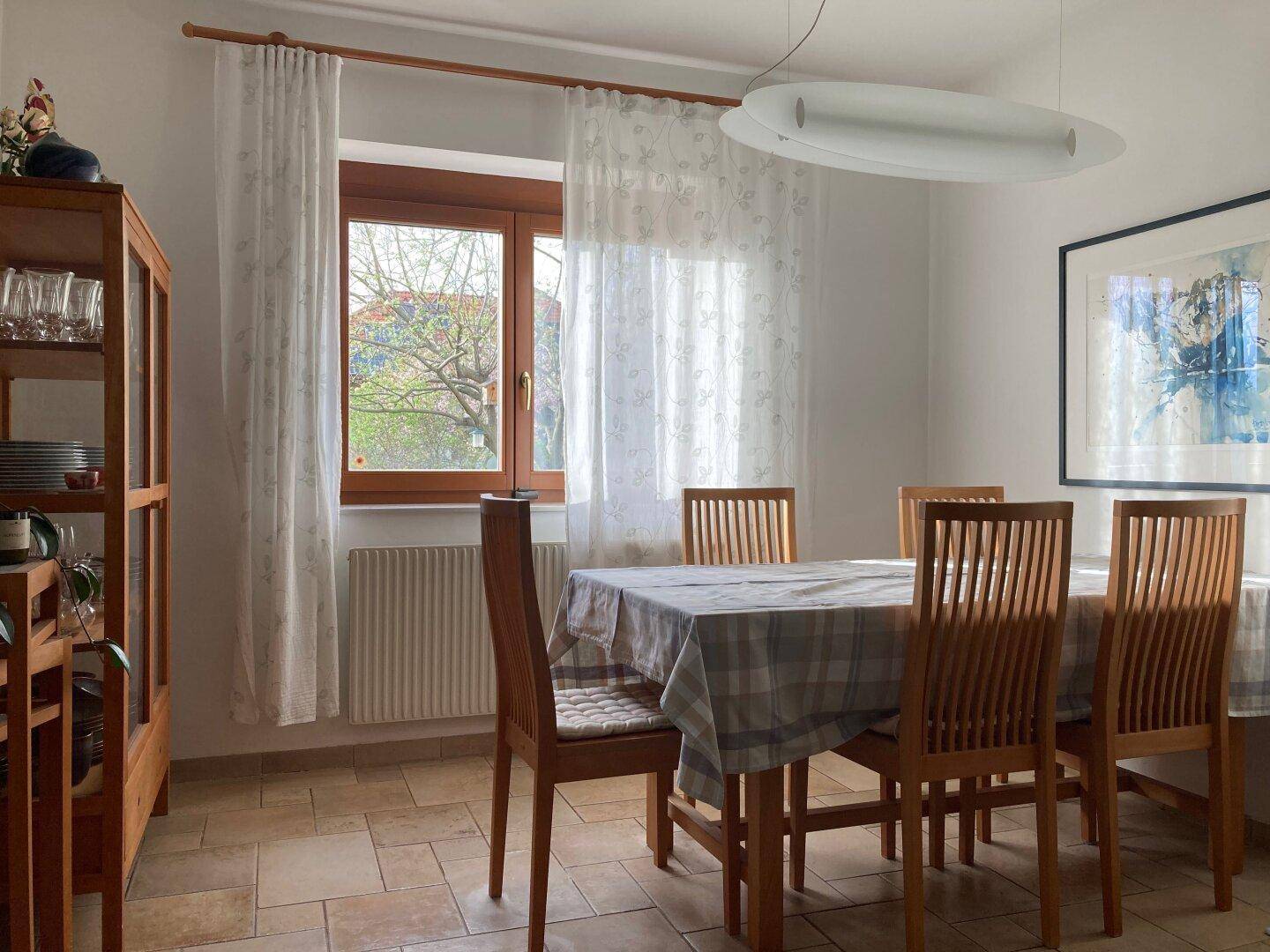 Heller Essbereich mit Holztisch, Stühlen und Fliesenboden, ideal für Familienmahlzeiten.
