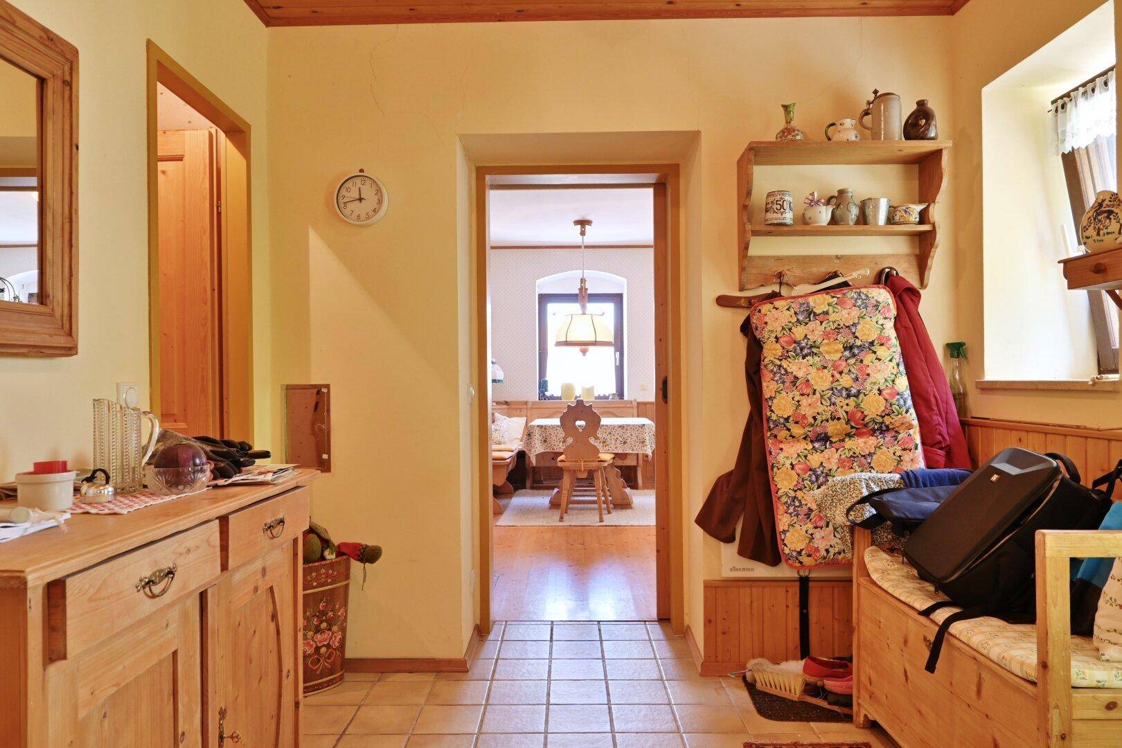 Geräumiger Flur mit Fliesenboden und Durchgang zum Essbereich, eingerichtet im traditionellen Stil.