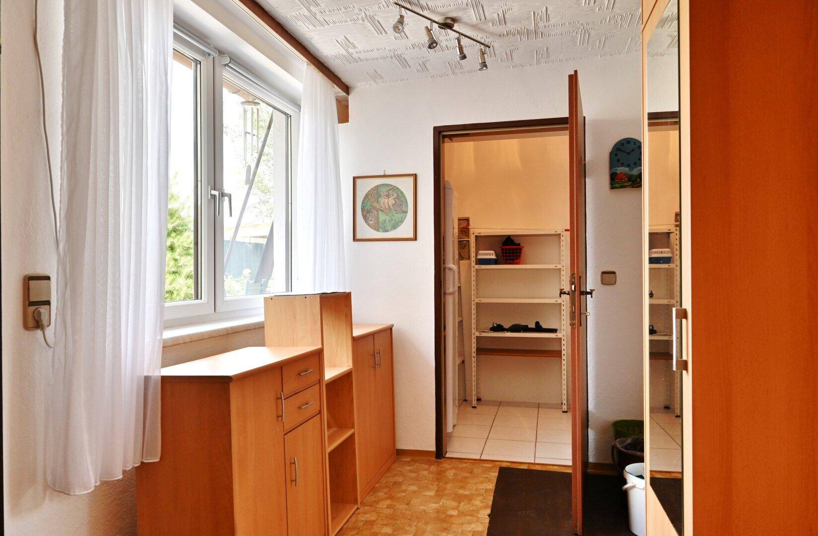 Abstellraum mit Regalen und Fenster, ideal für Vorräte oder Haushaltsgeräte.