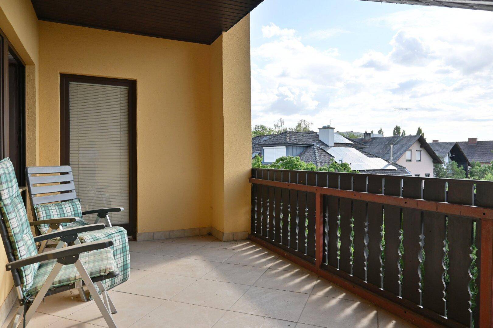 Geräumiger Balkon mit Fliesenboden und Gartenmöbeln, bietet einen weiten Blick.