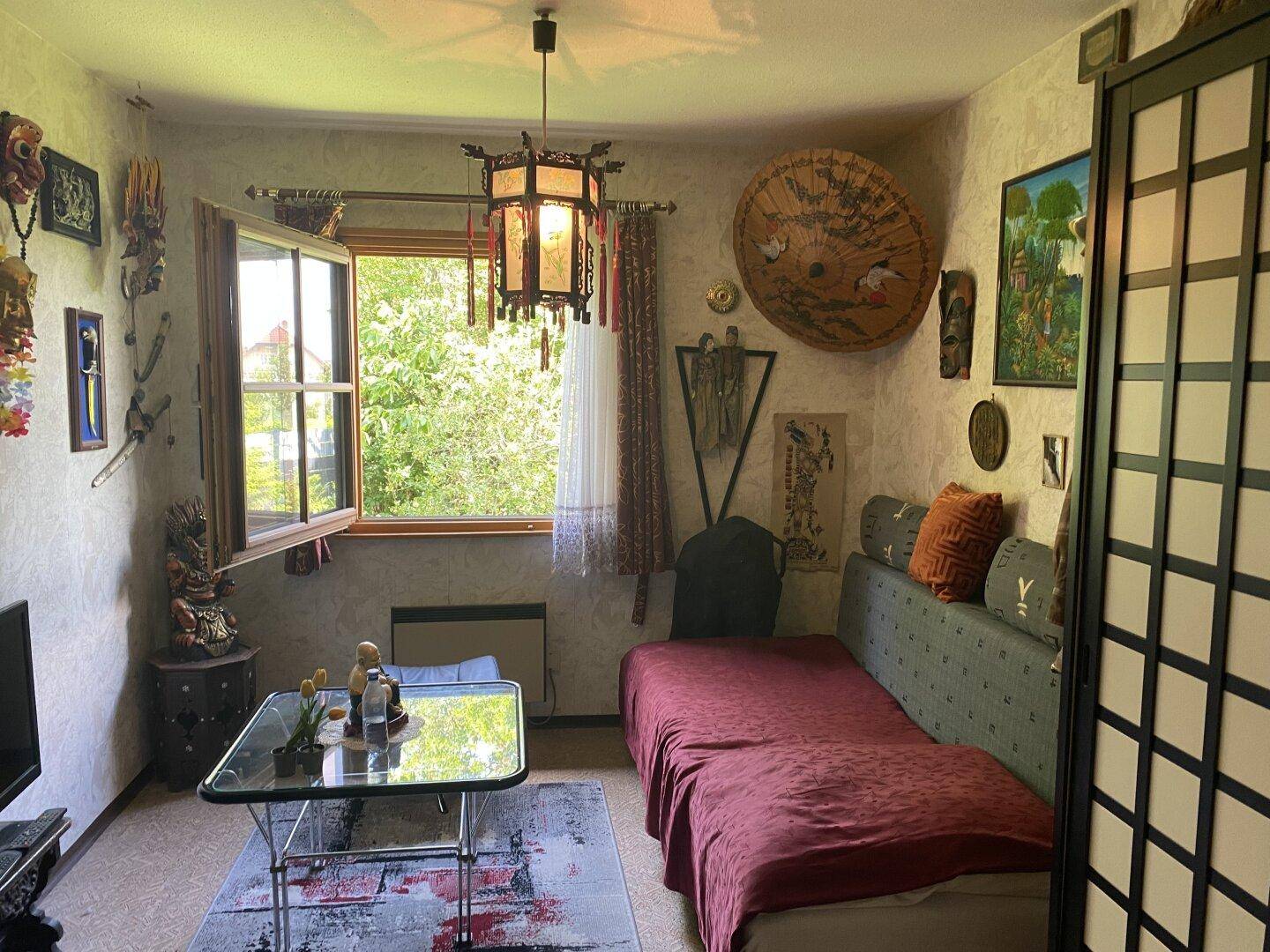 Kleines Schlafzimmer mit Einzelbett und asiatisch inspirierten Dekorationen.