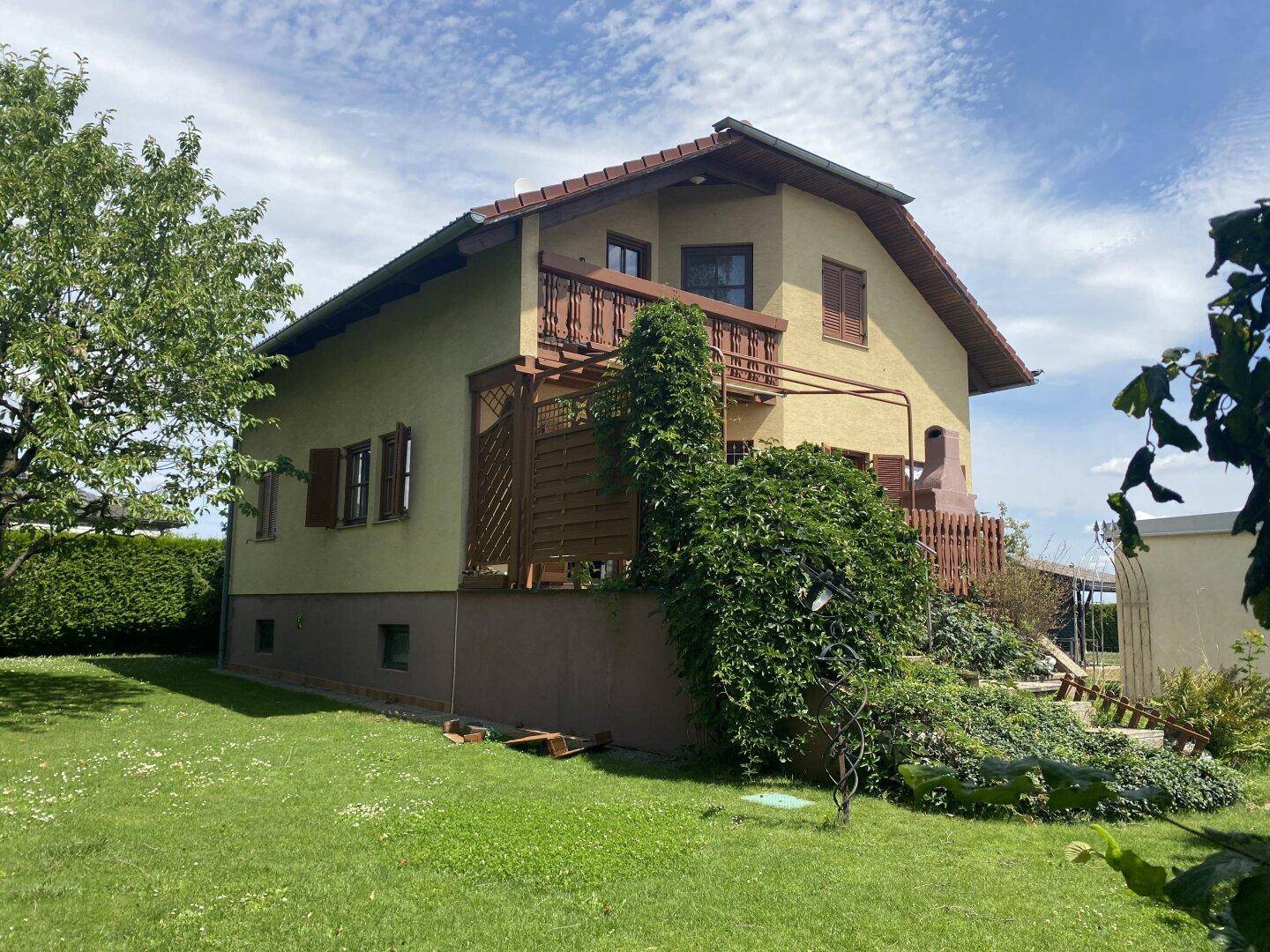 Seitenansicht des Hauses mit großem Garten und üppiger Bepflanzung.
