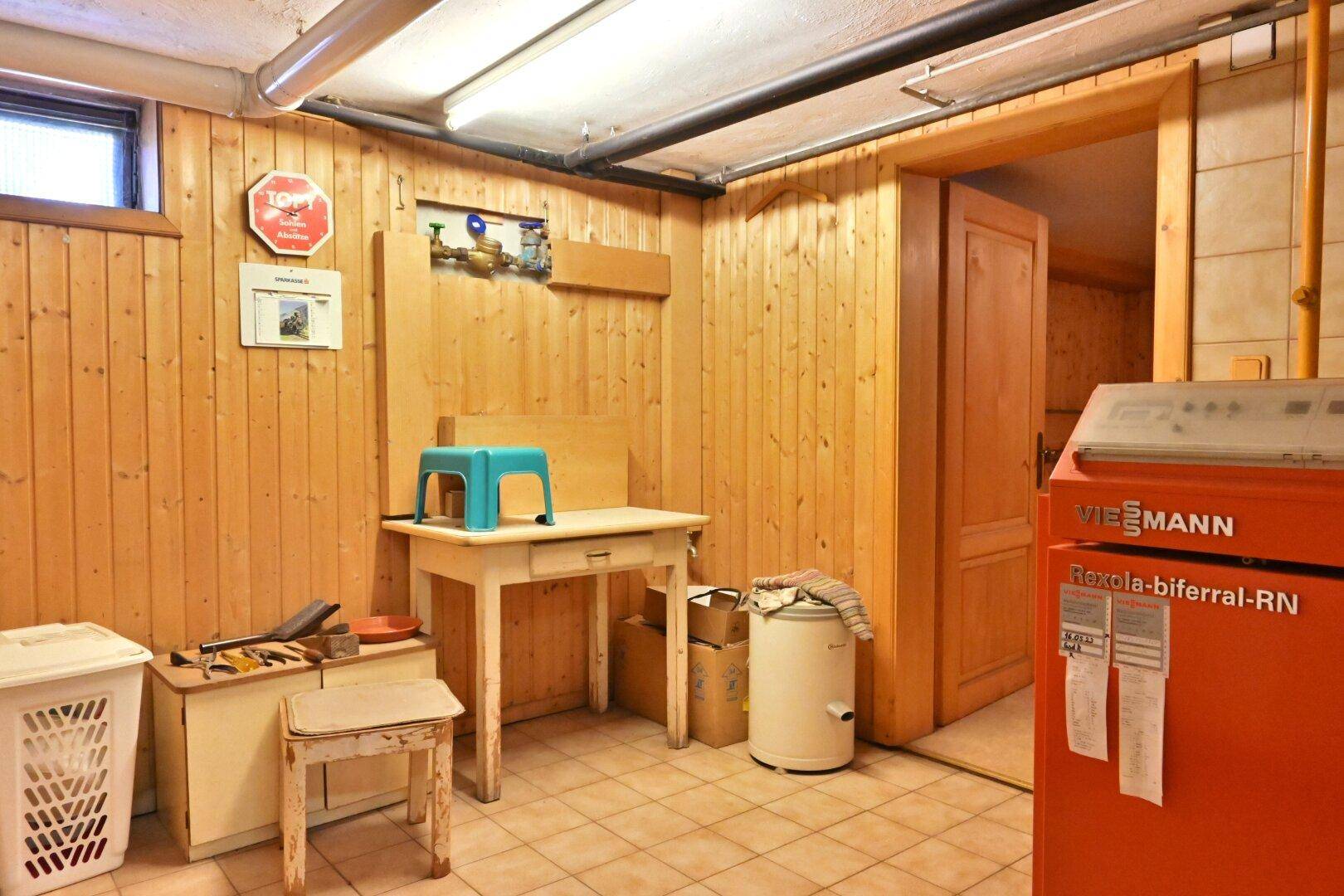 Heizungsraum im Keller mit Holzvertäfelung und Heizkessel.