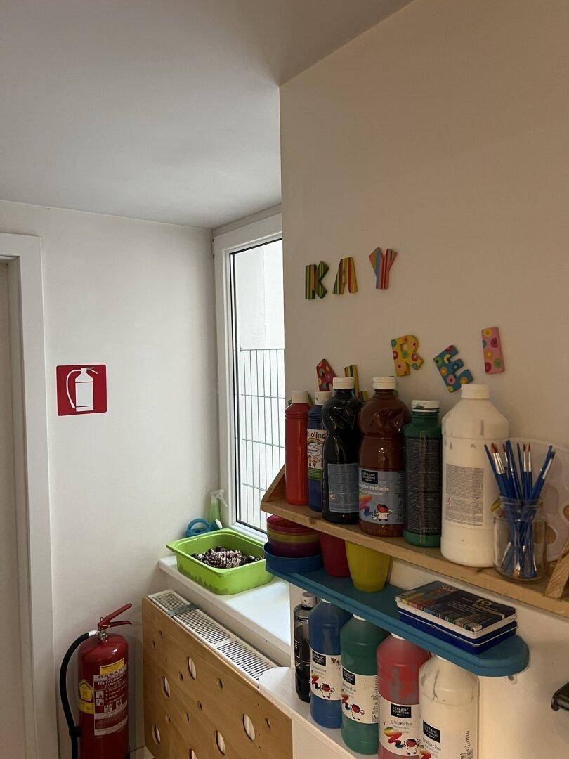 Kreativer Bereich mit Regalen voller Bastelmaterialien und einem Fenster, das Tageslicht hereinlässt.