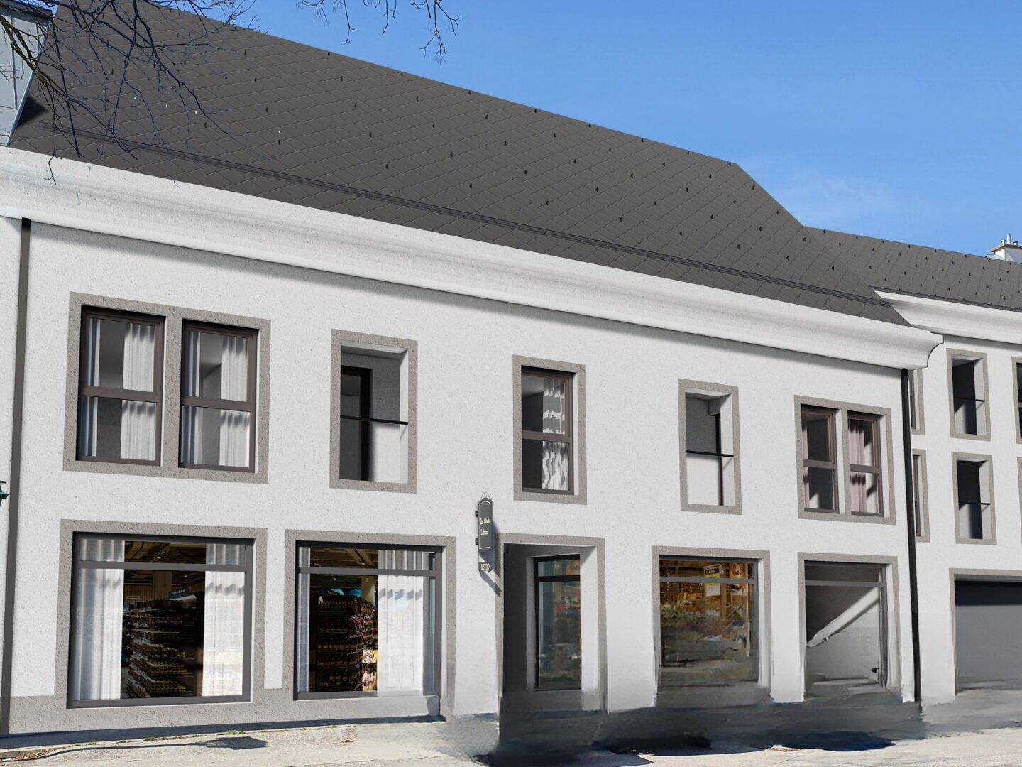 Fassade eines weißen Gebäudes mit grauen Fensterrahmen und Schaufenstern im Erdgeschoss.