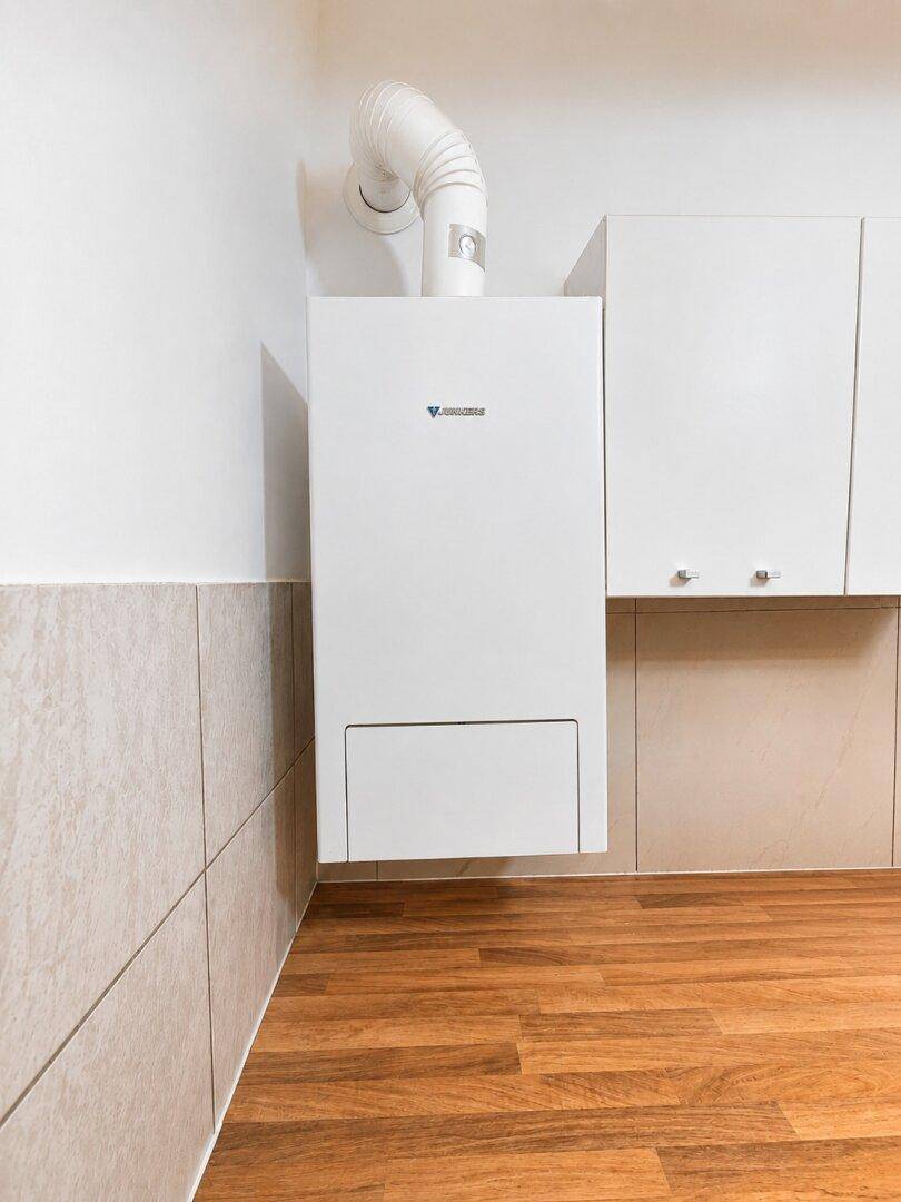 Nahaufnahme einer Gastherme über einer Holzarbeitsplatte in der Küche.
