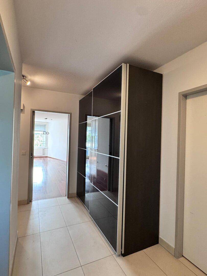 Flur mit modernem Einbauschrank und hellem Fliesenboden.