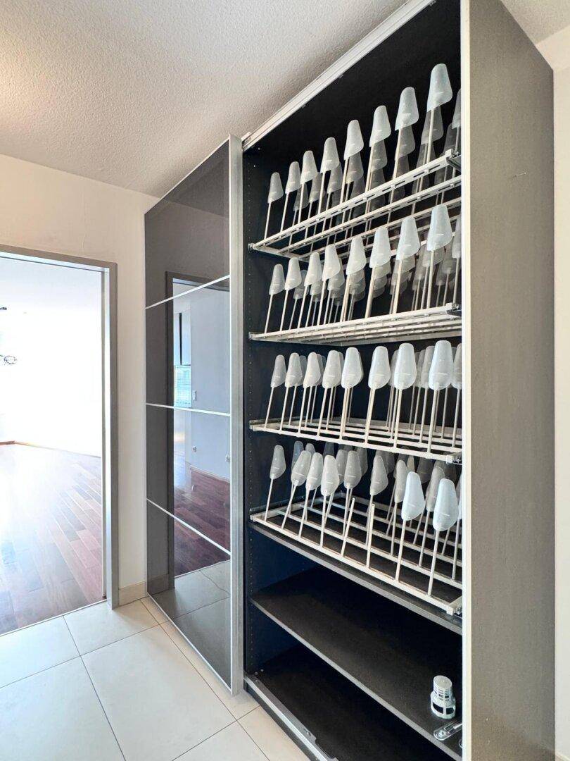 Offener Einbauschrank im Flur mit praktischen Schuhregalen.