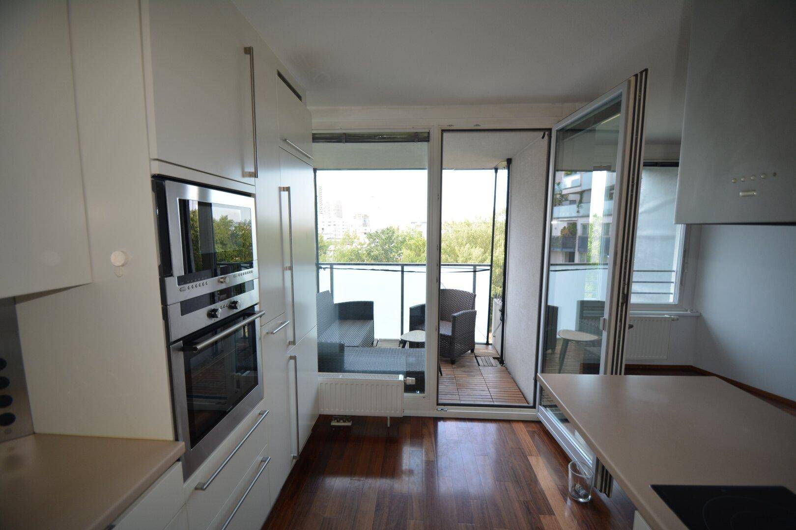 Küchenzeile mit integrierten Backöfen und direktem Zugang zum Balkon.