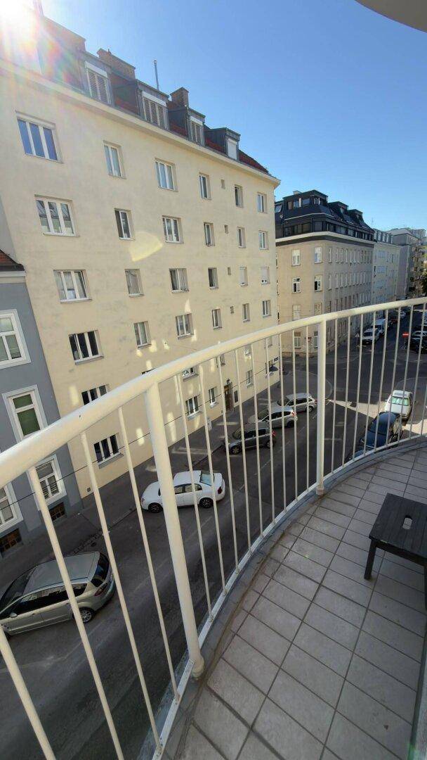 Balkon mit Blick auf die Straße und umliegende Gebäude in der Stadt.