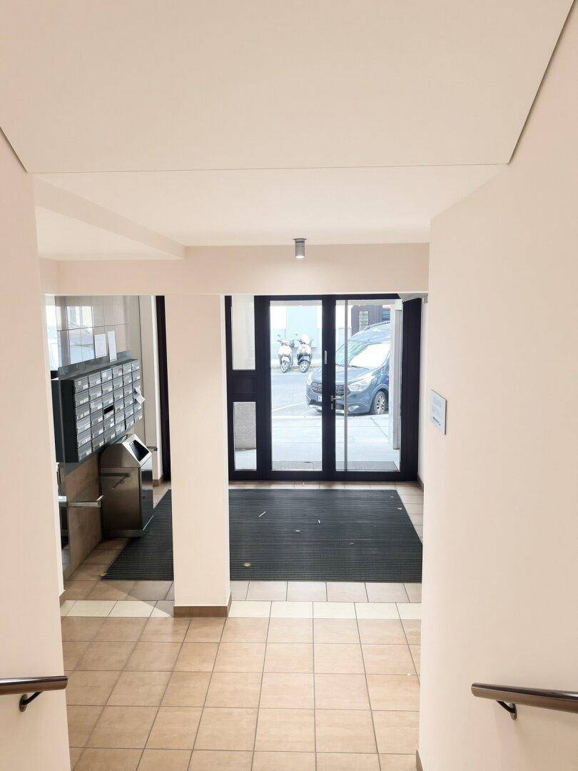 Eingangsbereich des Gebäudes mit Briefkästen und Zugang zur Straße.