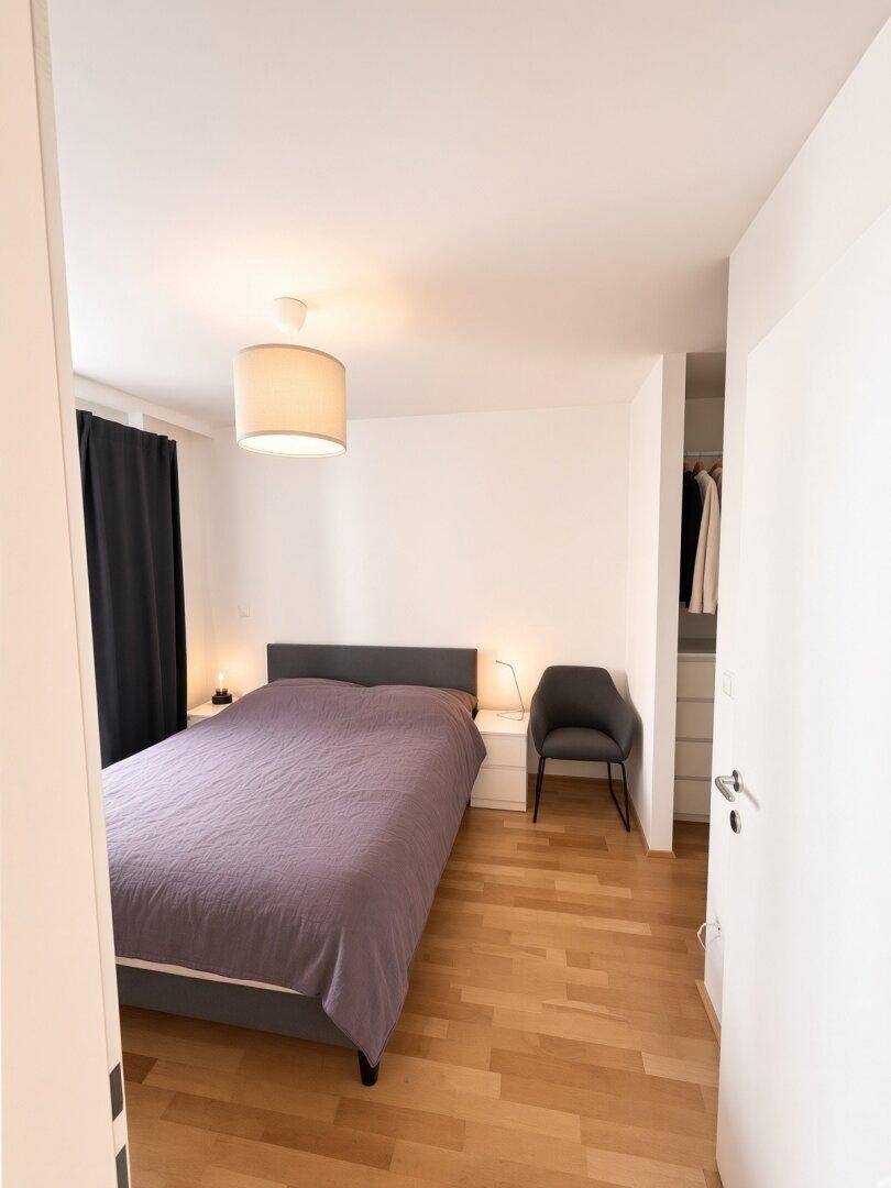 Schlafzimmer mit Doppelbett, Nachttischen und integriertem Kleiderschrank.