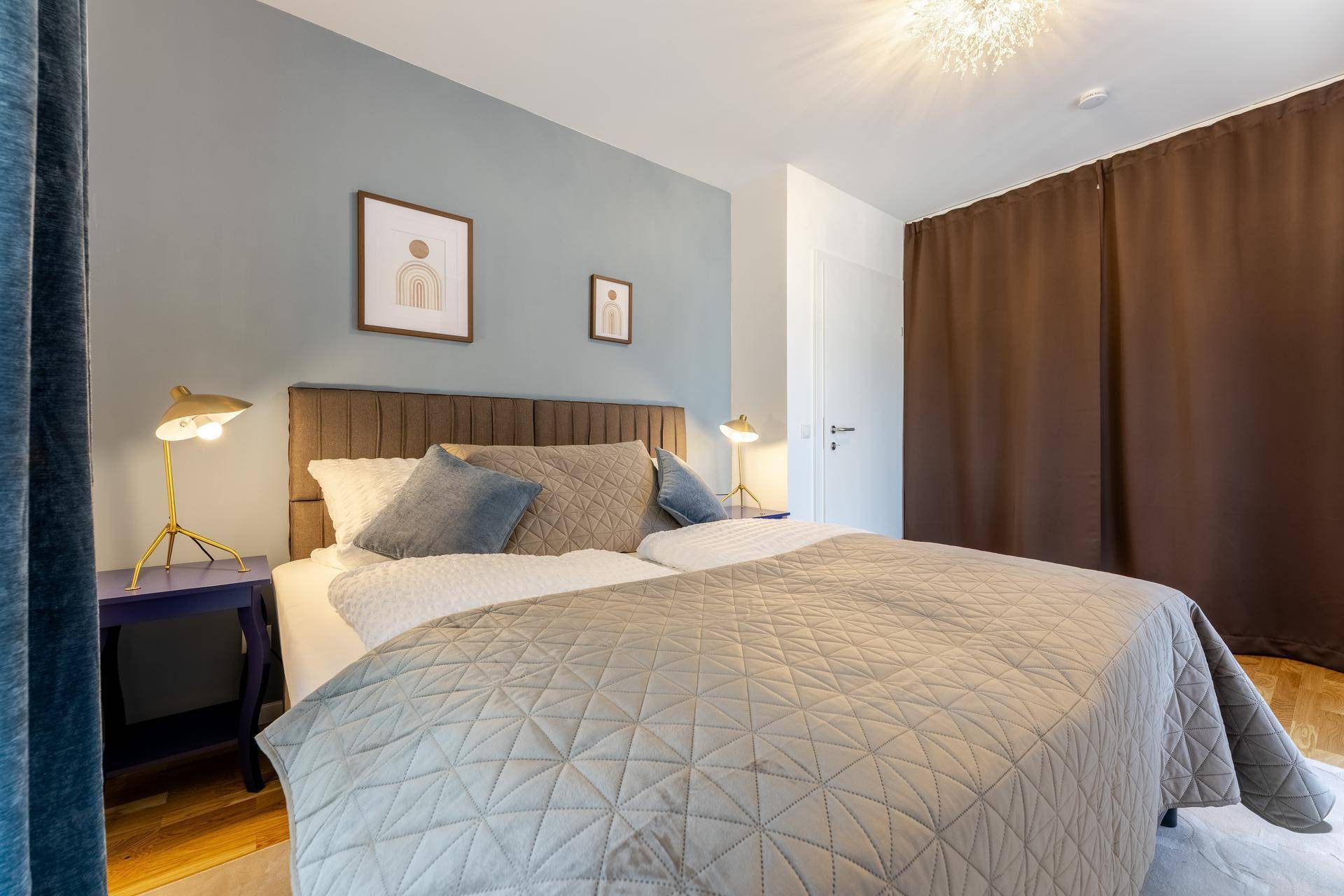Modern eingerichtetes Schlafzimmer mit großem Bett, Nachttischen und indirekter Beleuchtung.