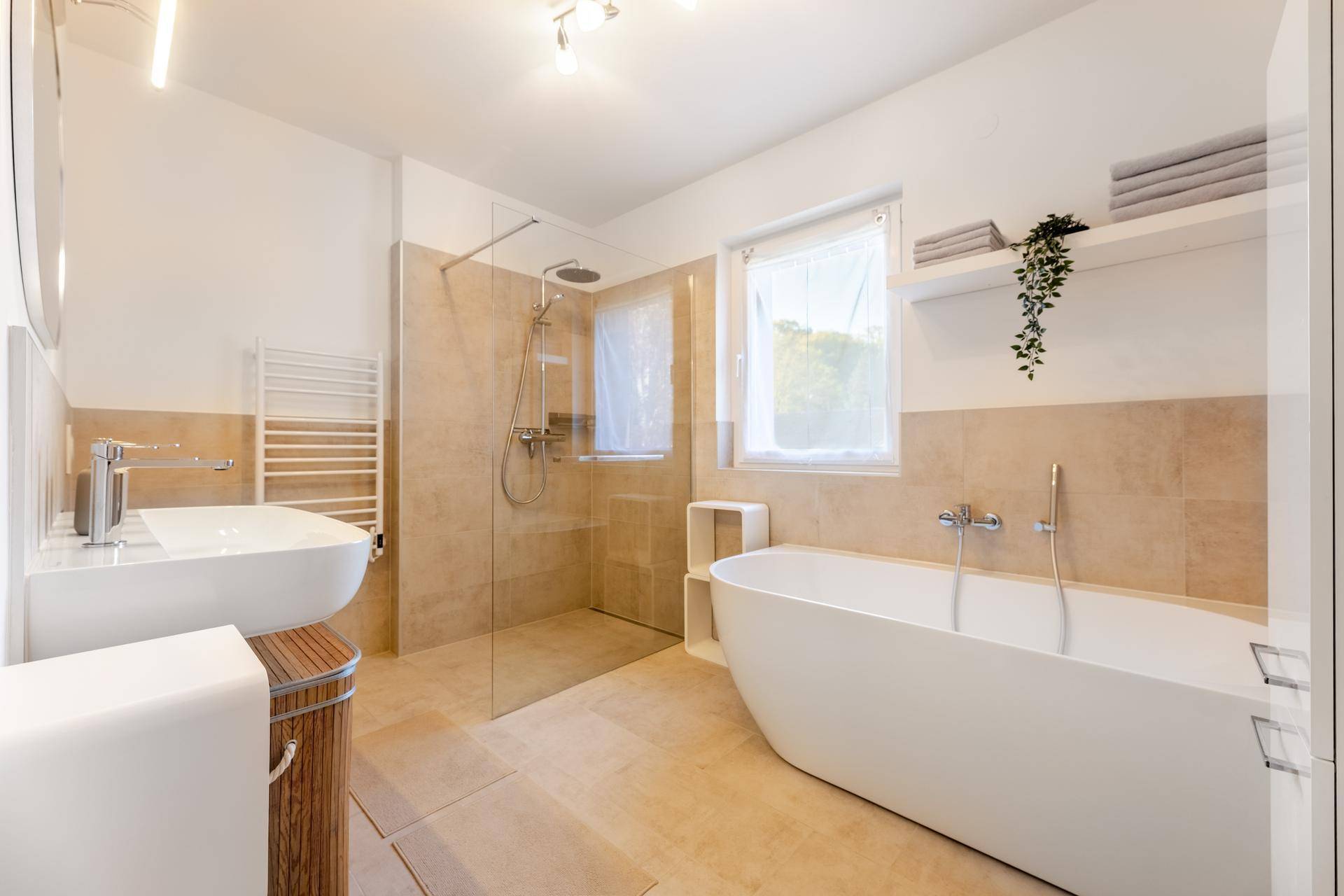 Großes modernes Badezimmer mit freistehender Badewanne, begehbarer Dusche und Fenster.
