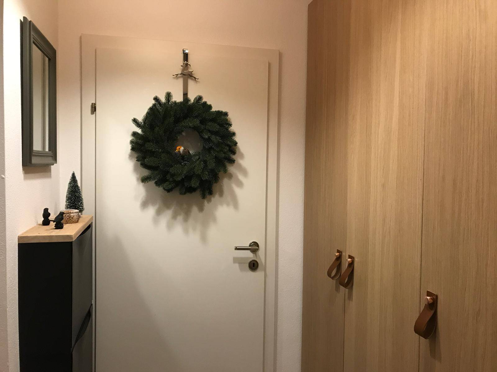 Eingangsbereich mit Holzböden, eingebauten Kleiderschränken und festlicher Dekoration.
